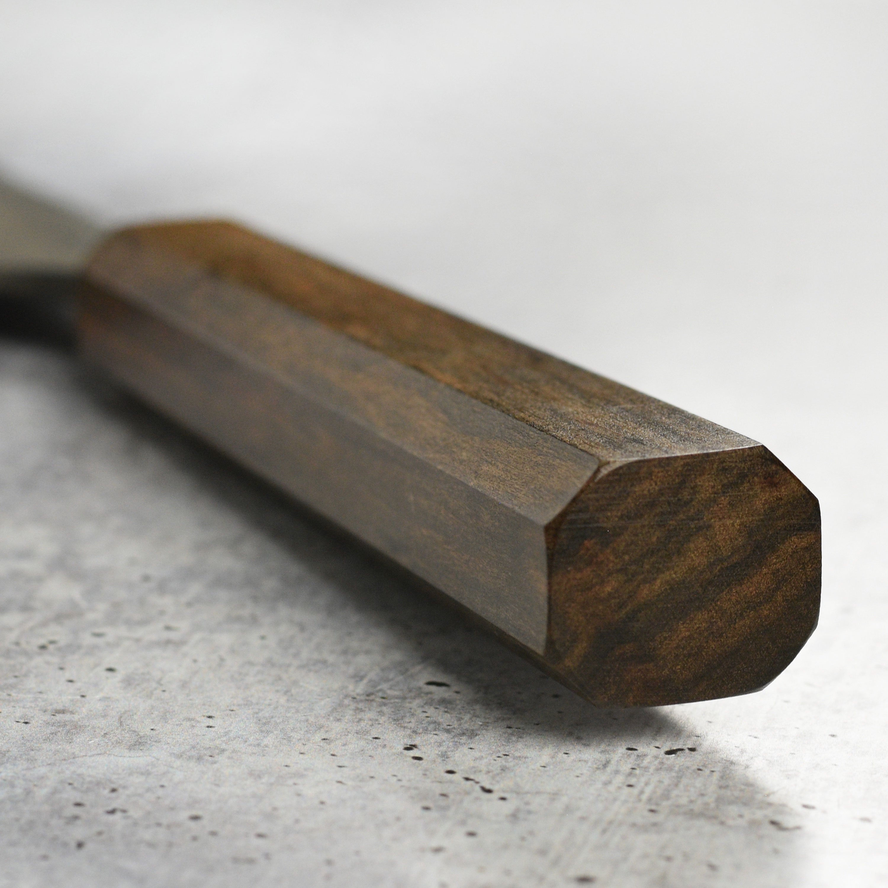 Detail shot of the high carbon steel blade and bubinga handle of the Japanese kitchen knife
