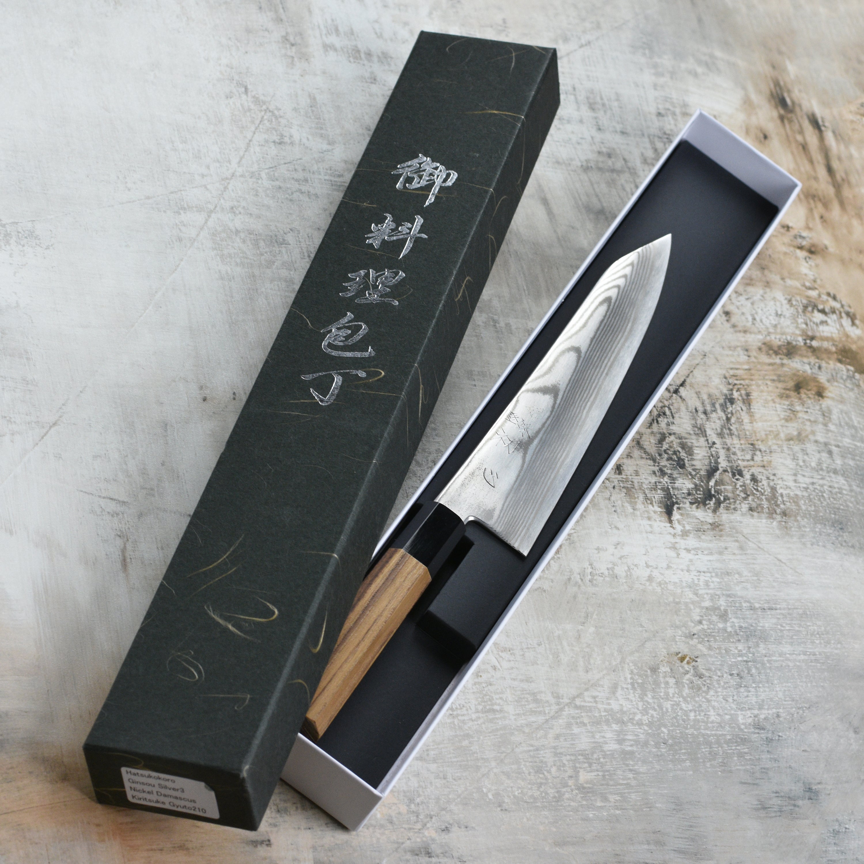 Close-up of Hatsukokoro Ginsou Damascus Gyuto Chef Knife showcasing its sharp blade and ergonomic handle.