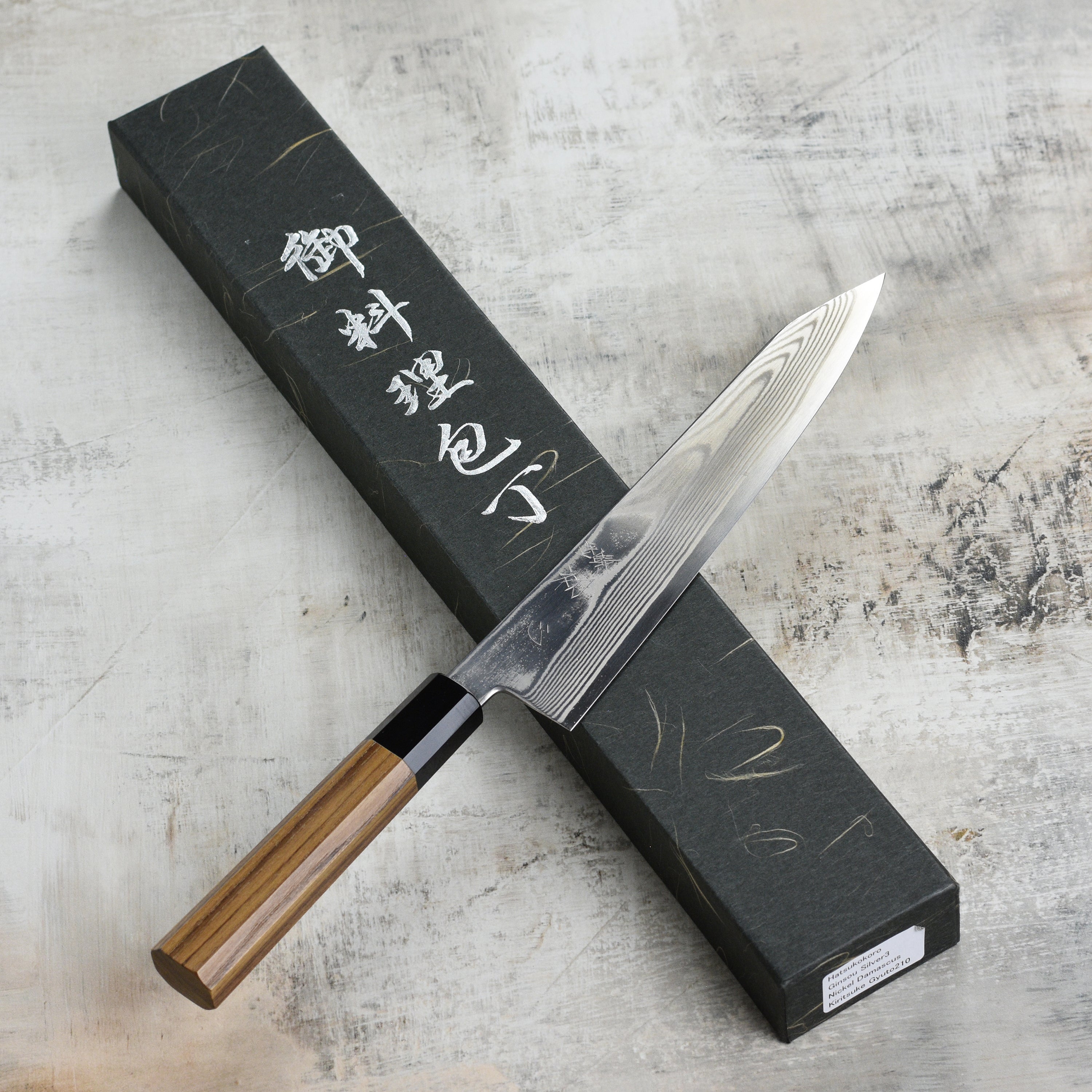 Close-up of Hatsukokoro Ginsou Damascus Gyuto Chef Knife showcasing its sharp blade and ergonomic handle.