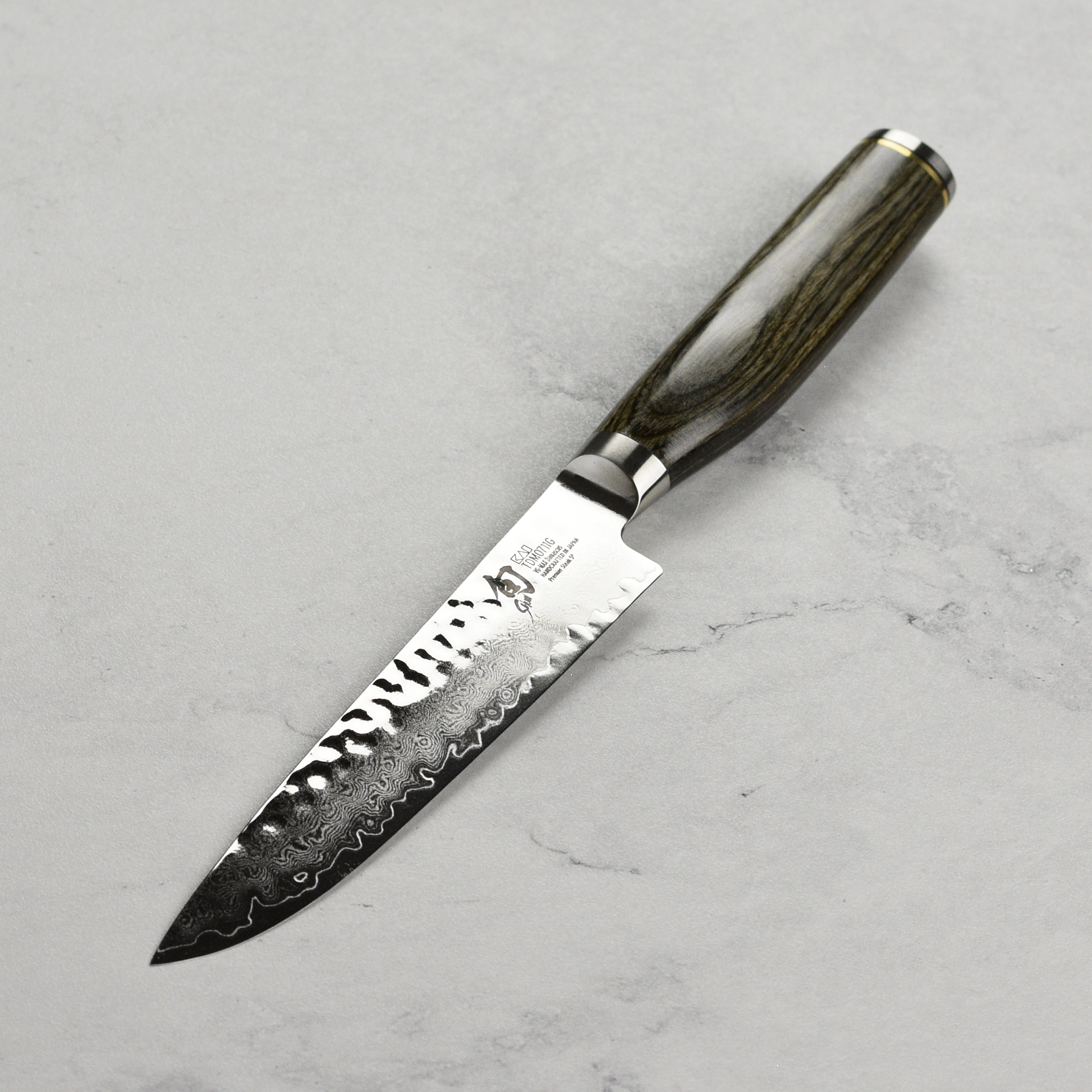 Shun Premier steak knife in action, slicing through a juicy steak on a wooden cutting board.