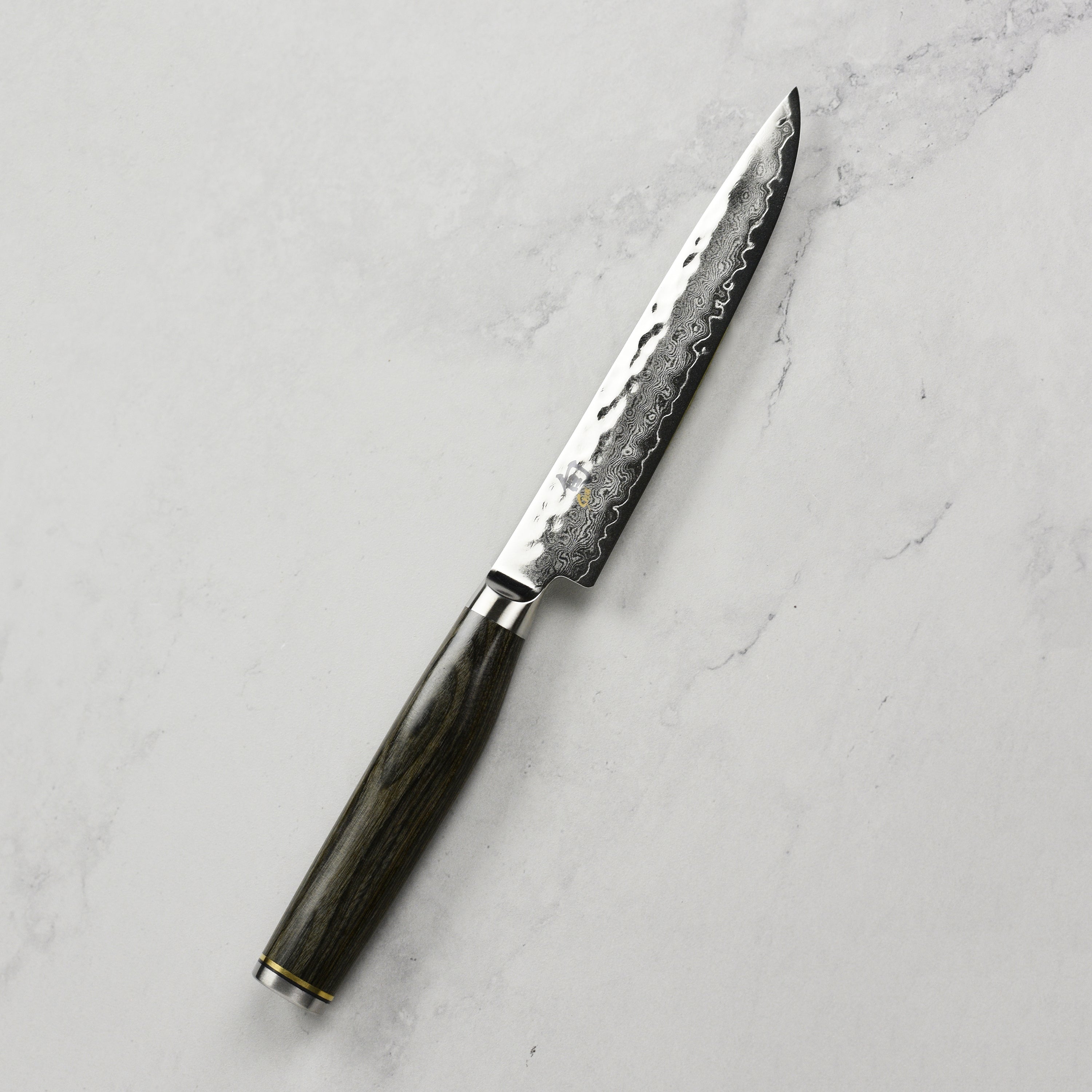 Close-up view of the Shun Premier Damascus steak knife blade with a focus on the layered steel.