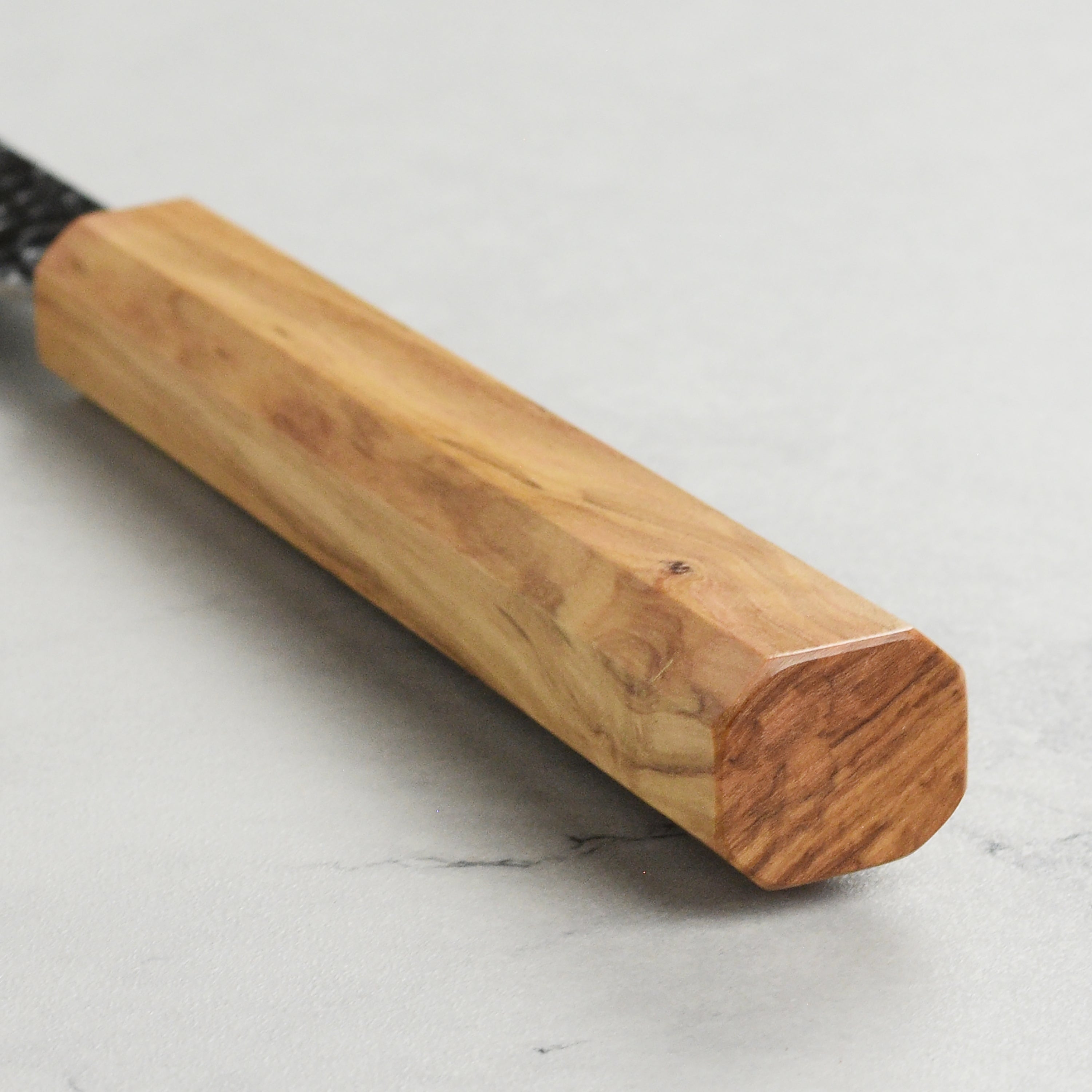 Professional chef knife in use chopping vegetables with ergonomic olivewood handle