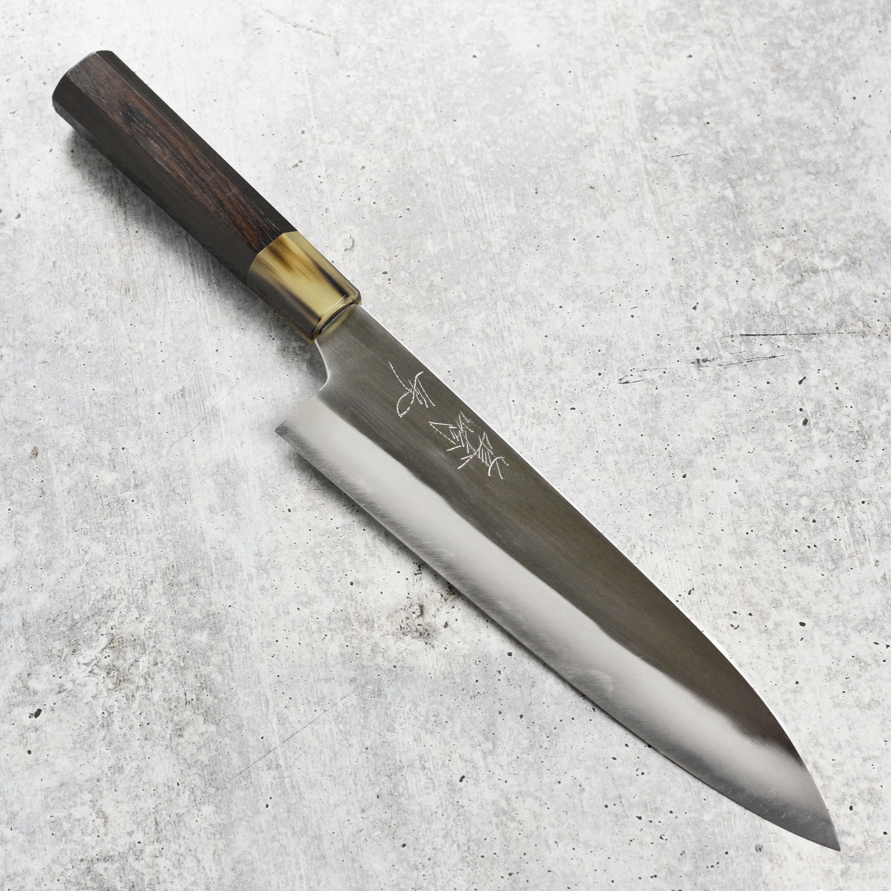 Mazaki gyuto knife slicing vegetables on a wooden cutting board