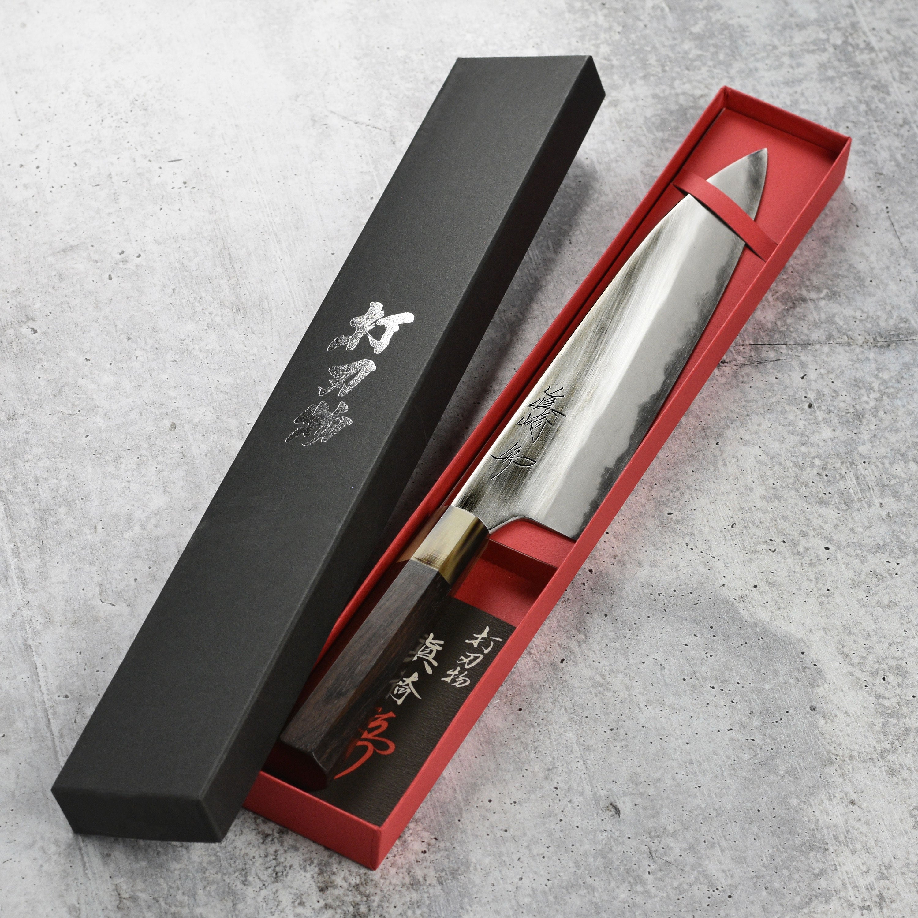 Mazaki gyuto knife slicing vegetables on a wooden cutting board