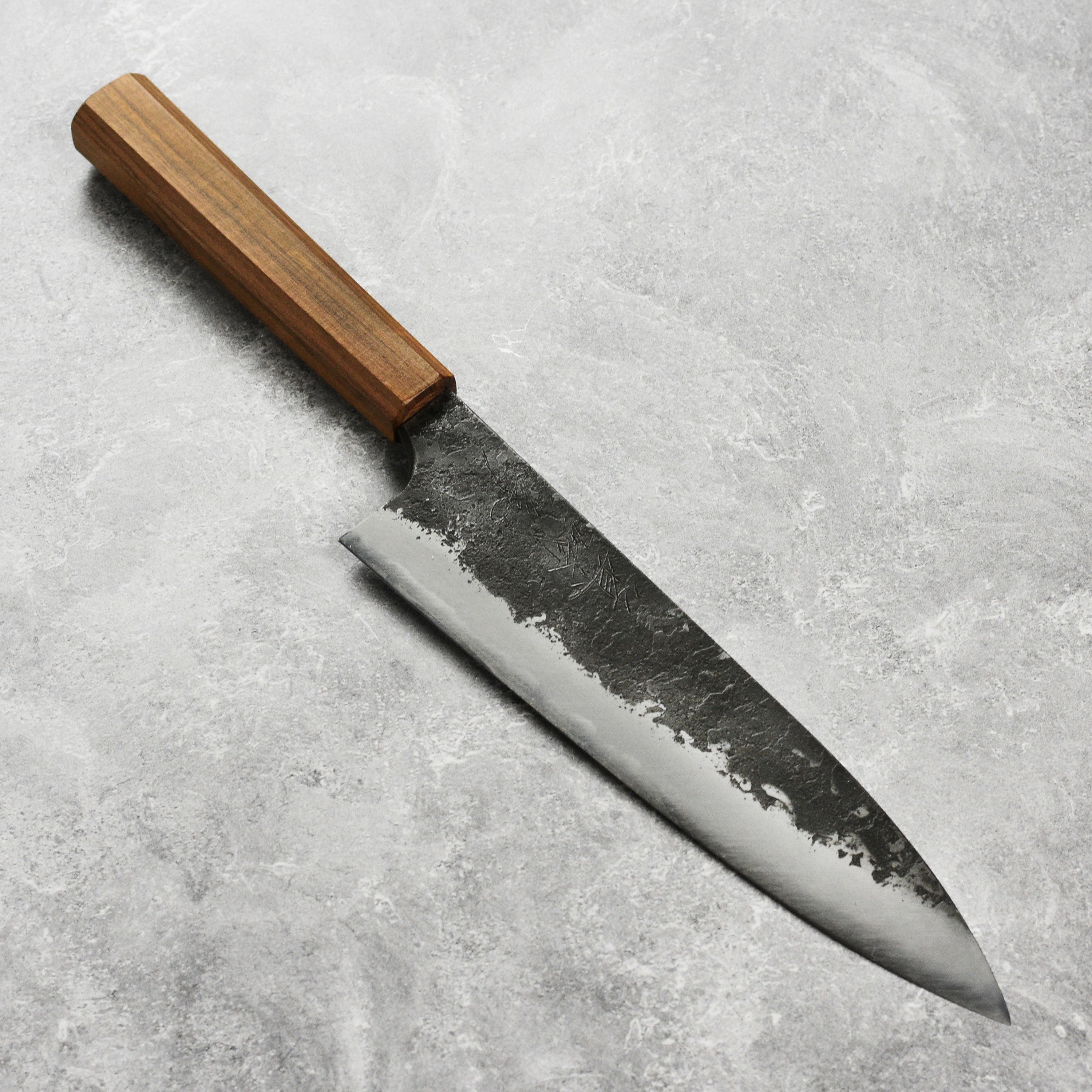 Close-up of the Mazaki Shirogami Kurouchi Gyuto knife blade highlighting its sharpness and craftsmanship.