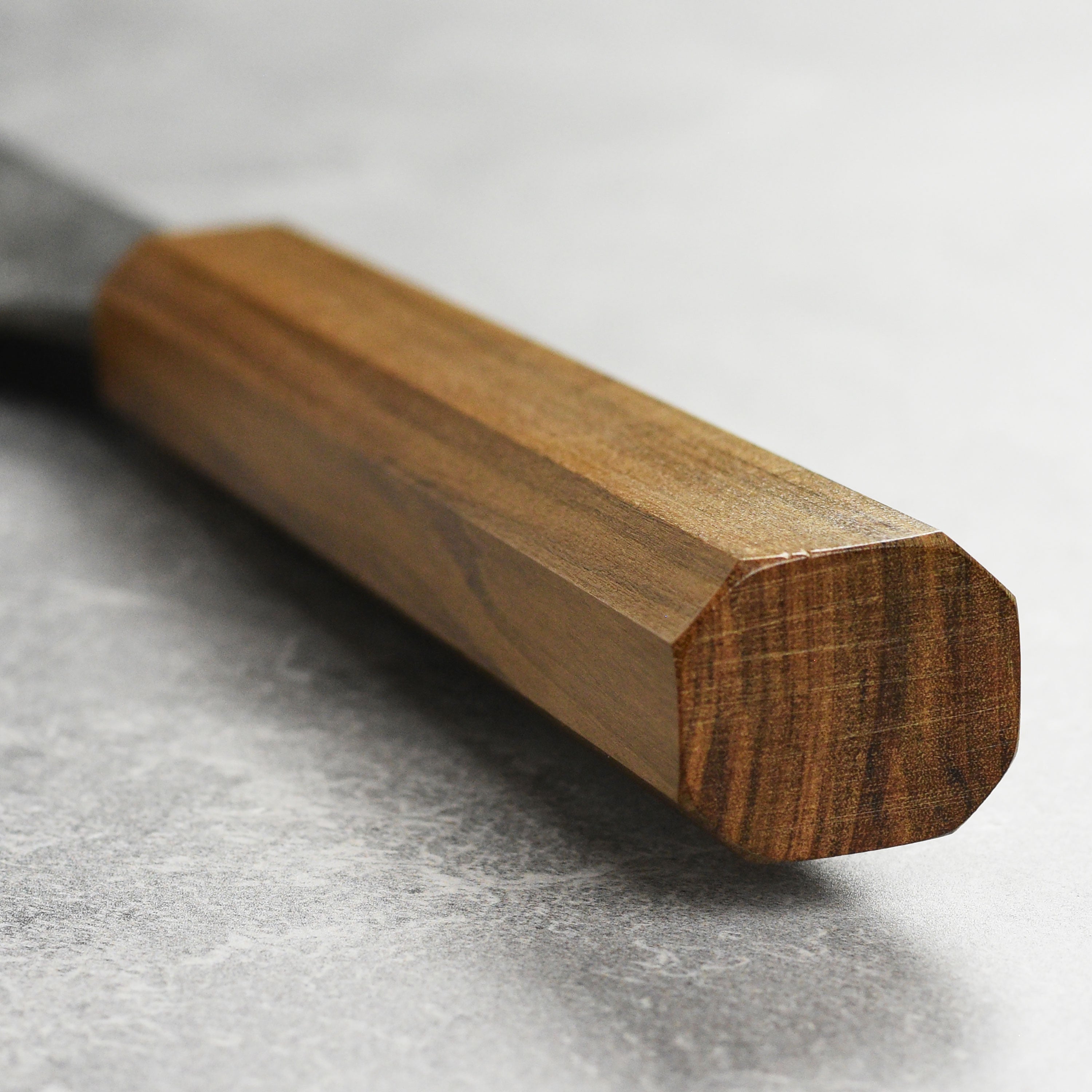 Mazaki Shirogami Kurouchi Gyuto knife in action, slicing through fresh vegetables with ease.