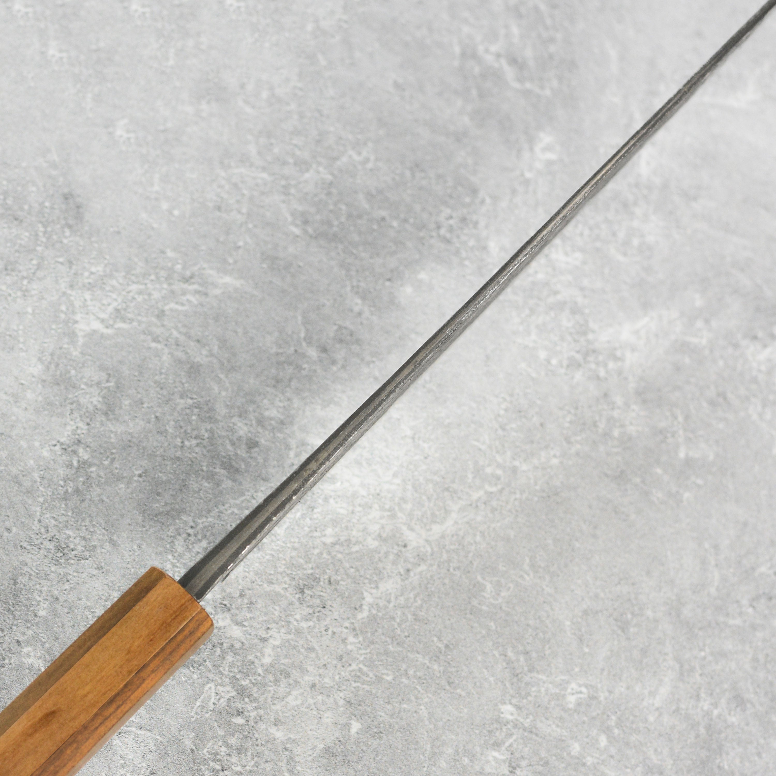 Mazaki Shirogami Kurouchi Gyuto knife in action, slicing through fresh vegetables with ease.