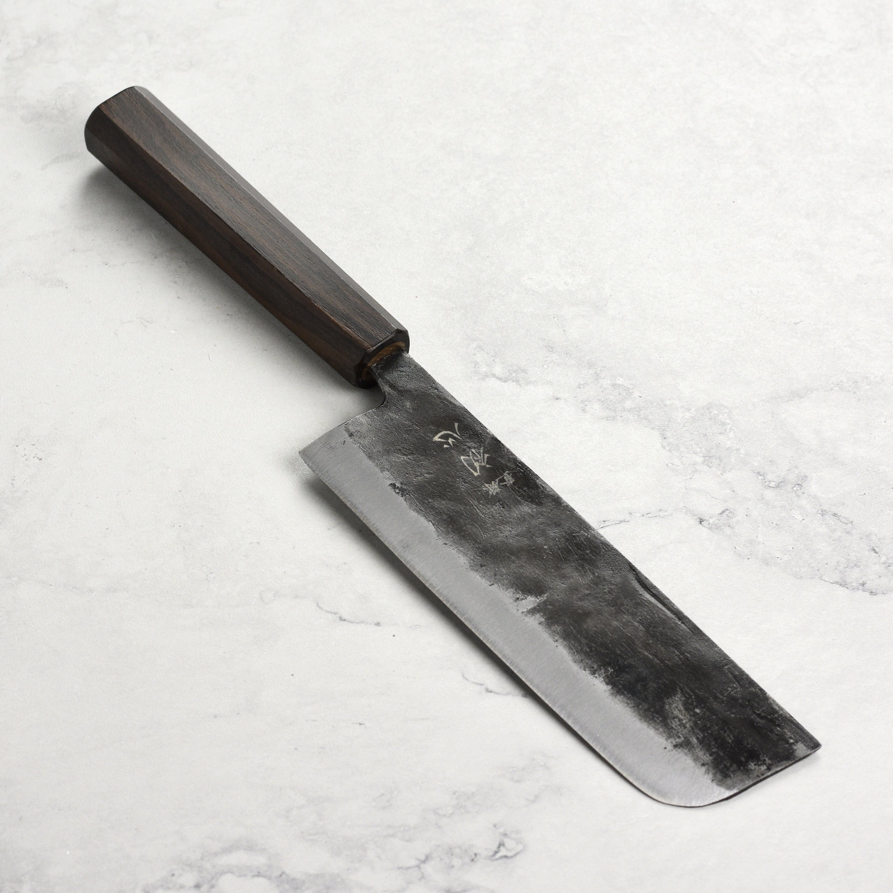 Hatsukokoro Nakiri knife showcasing its Aogami #2 Kurouchi blade on a kitchen table.