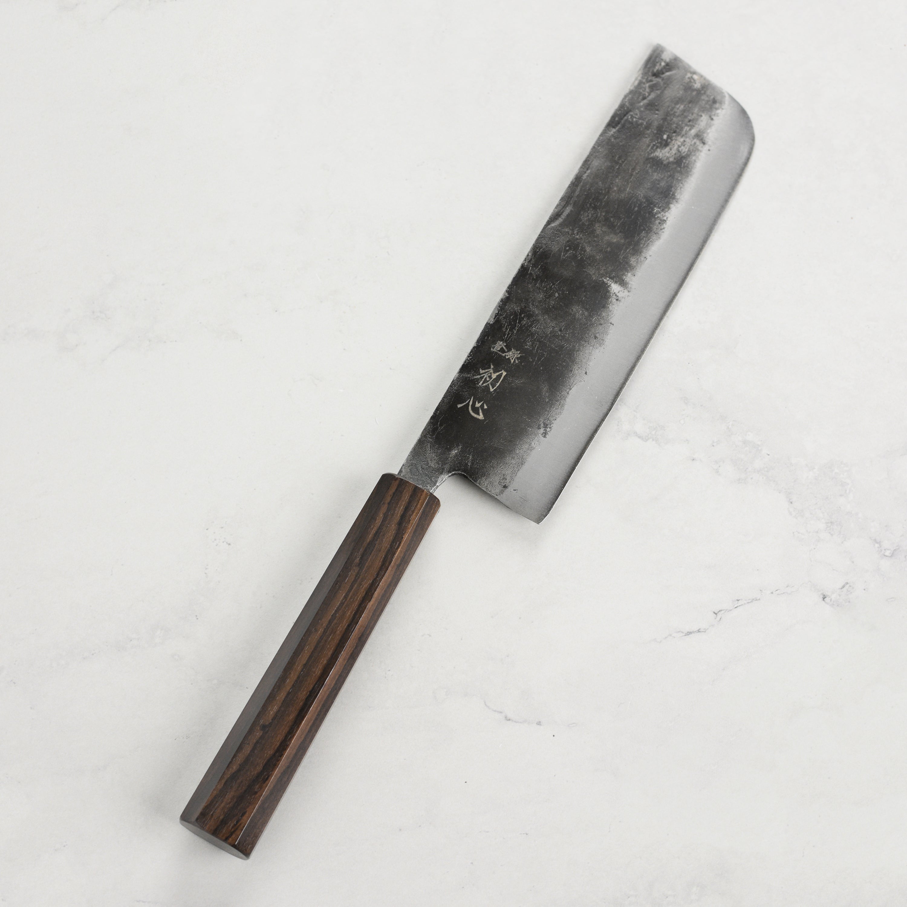 Chef using the Hatsukokoro Nakiri knife to chop fresh vegetables for a dish.