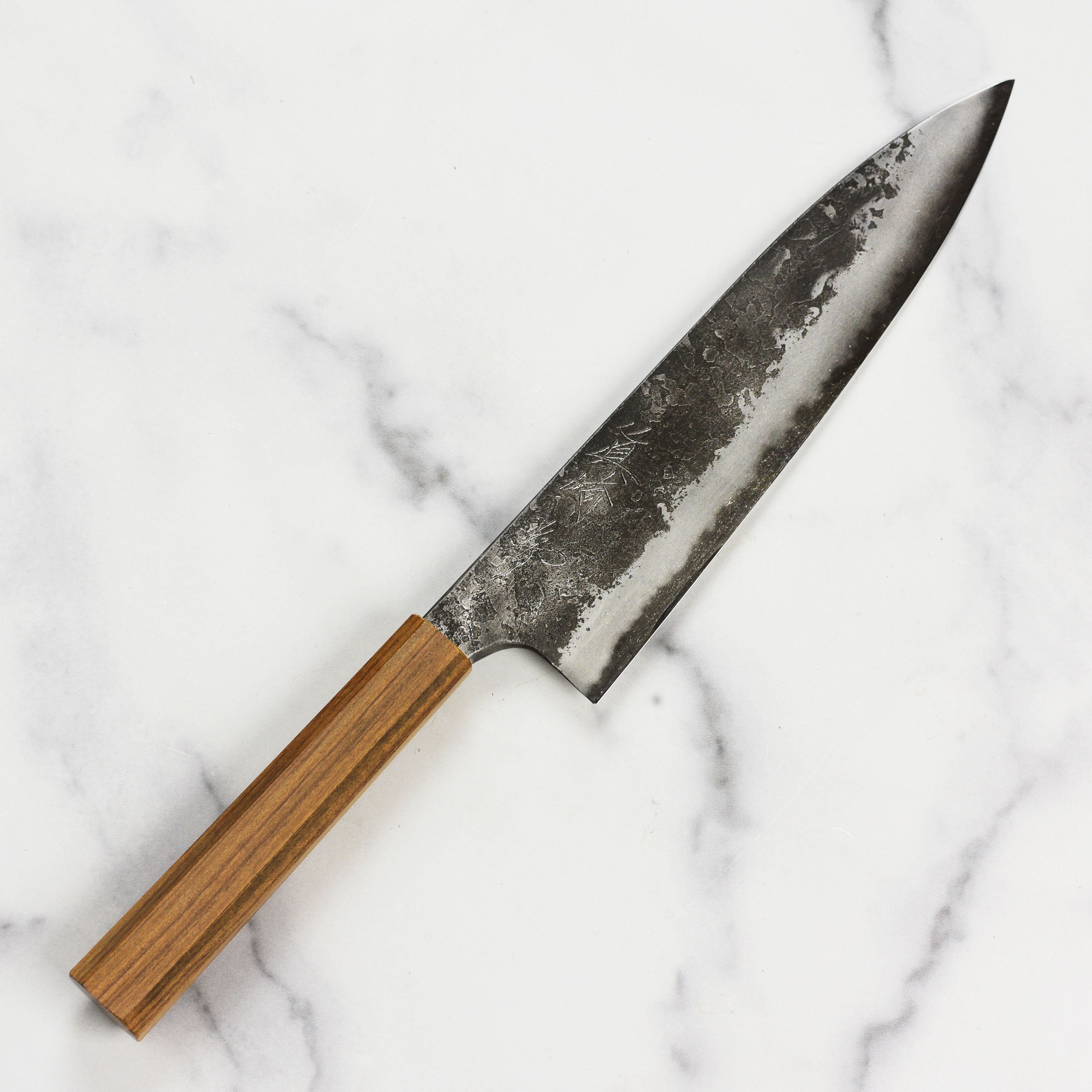 Side view of the Mazaki Shirogami Kurouchi Gyuto knife displaying its unique Kurouchi finish and ergonomic handle.