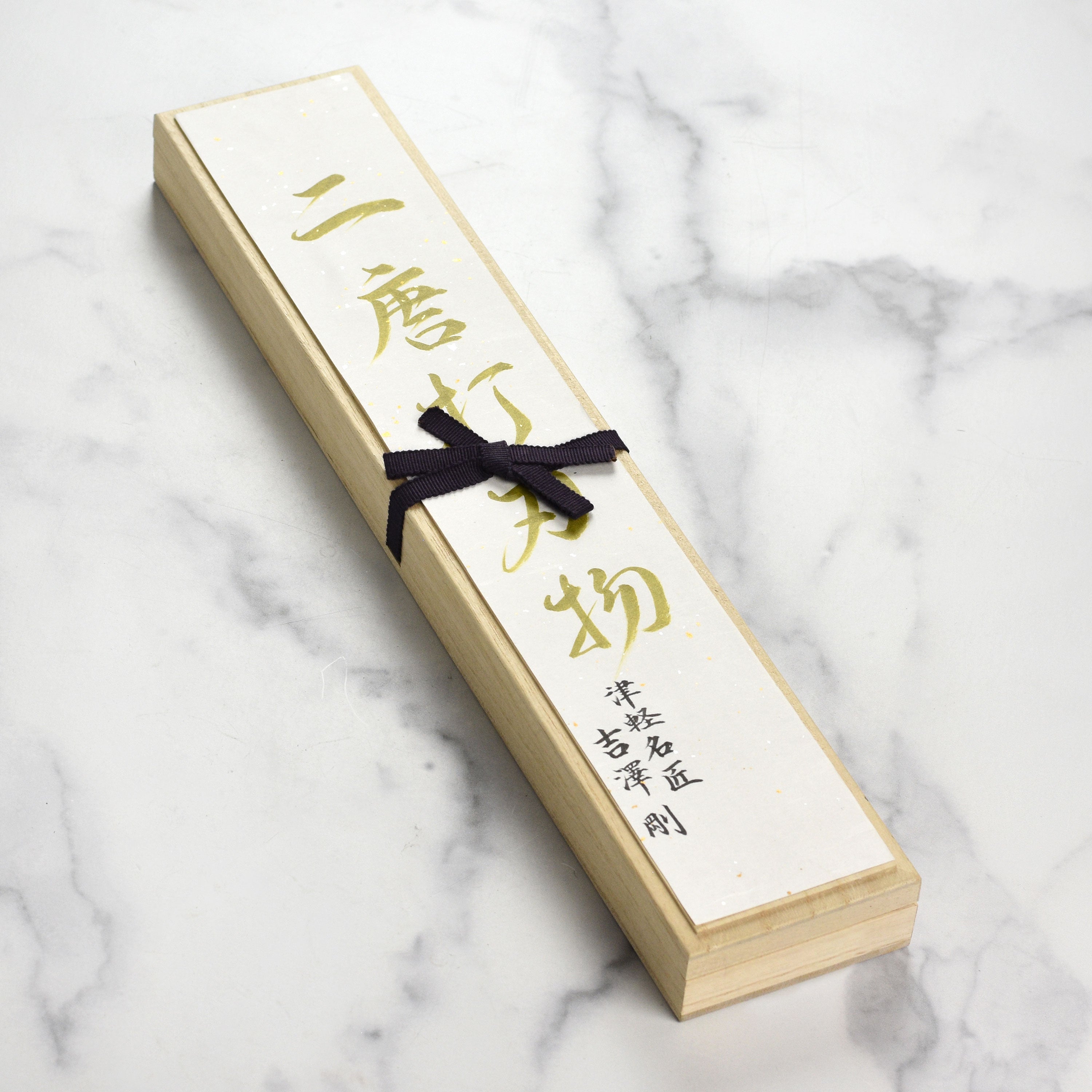 Side view of the 9.4" Japanese chef knife resting on a cutting board with fresh vegetables