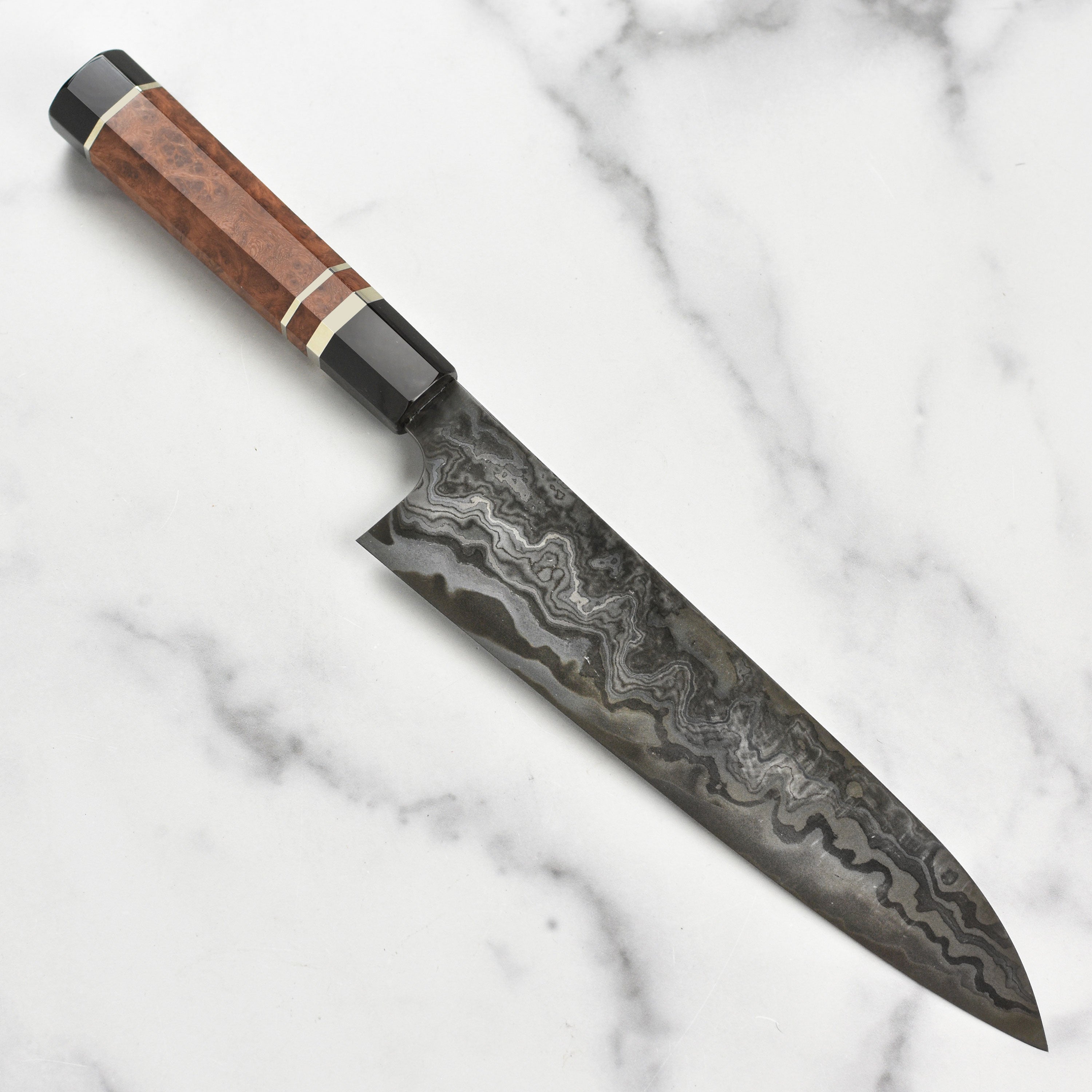 Close-up of the Nigara Kagetora Damascus knife showing intricate steel layering and polished edge