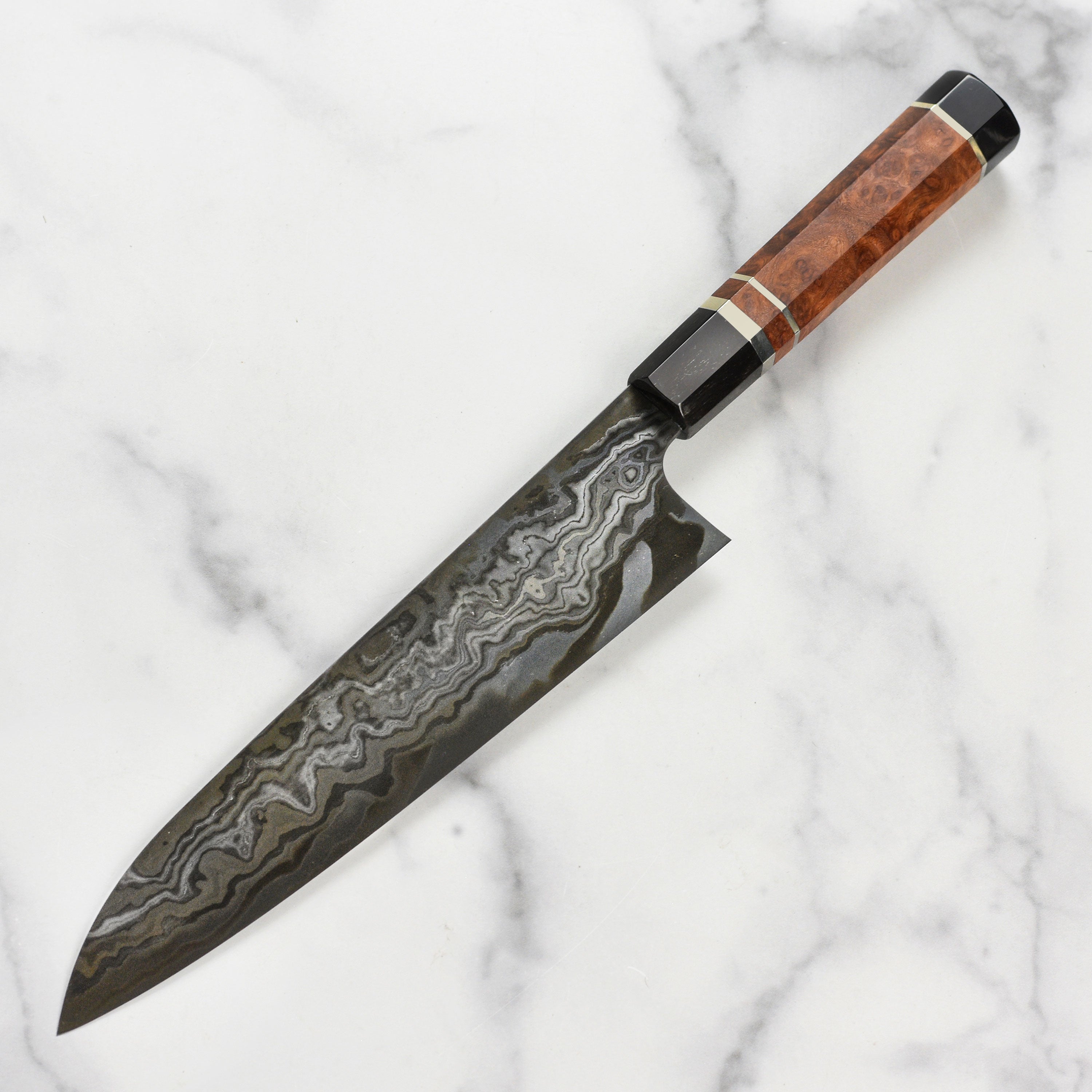 Side view of the 9.4" Japanese chef knife resting on a cutting board with fresh vegetables