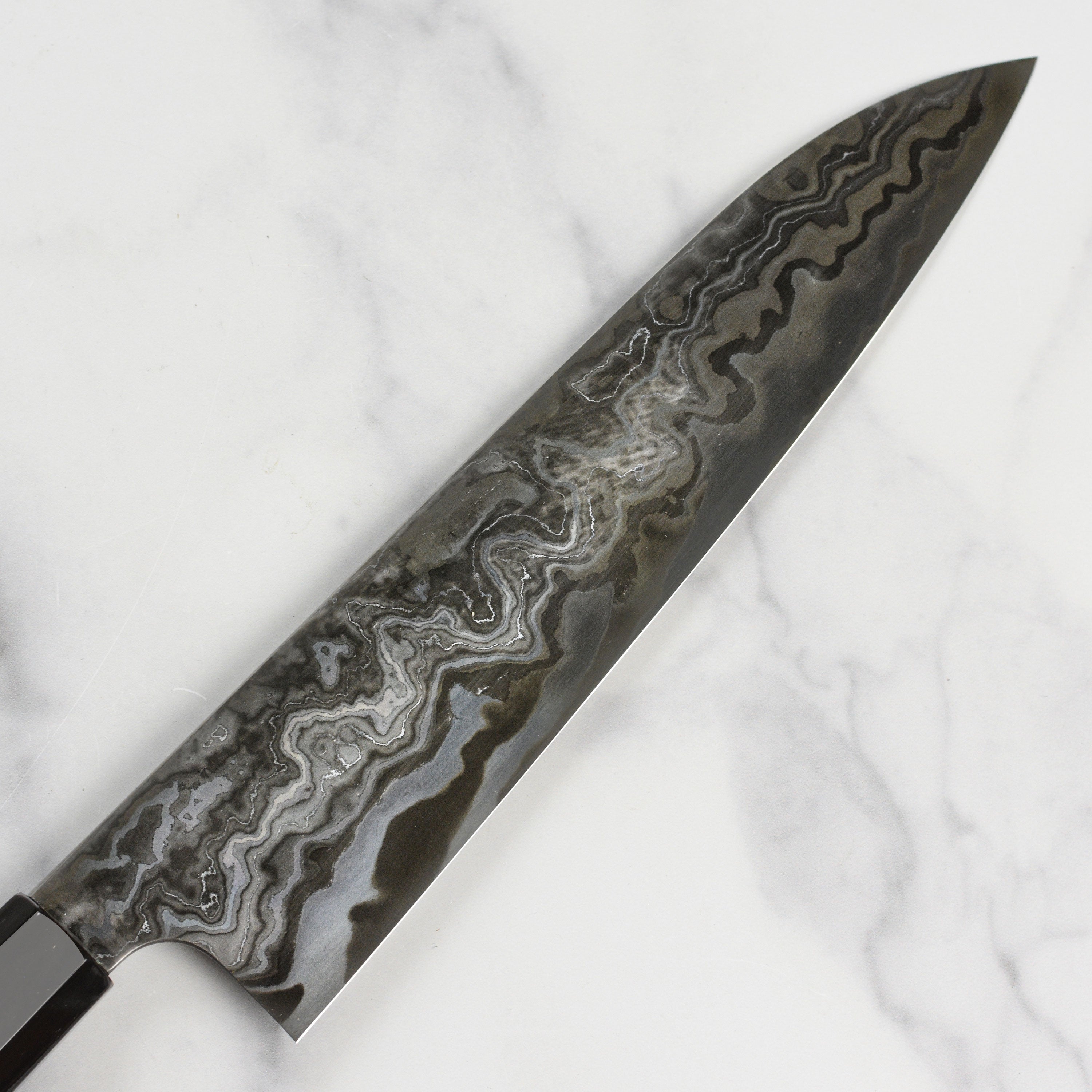 Close-up of the Nigara Kagetora Damascus knife showing intricate steel layering and polished edge
