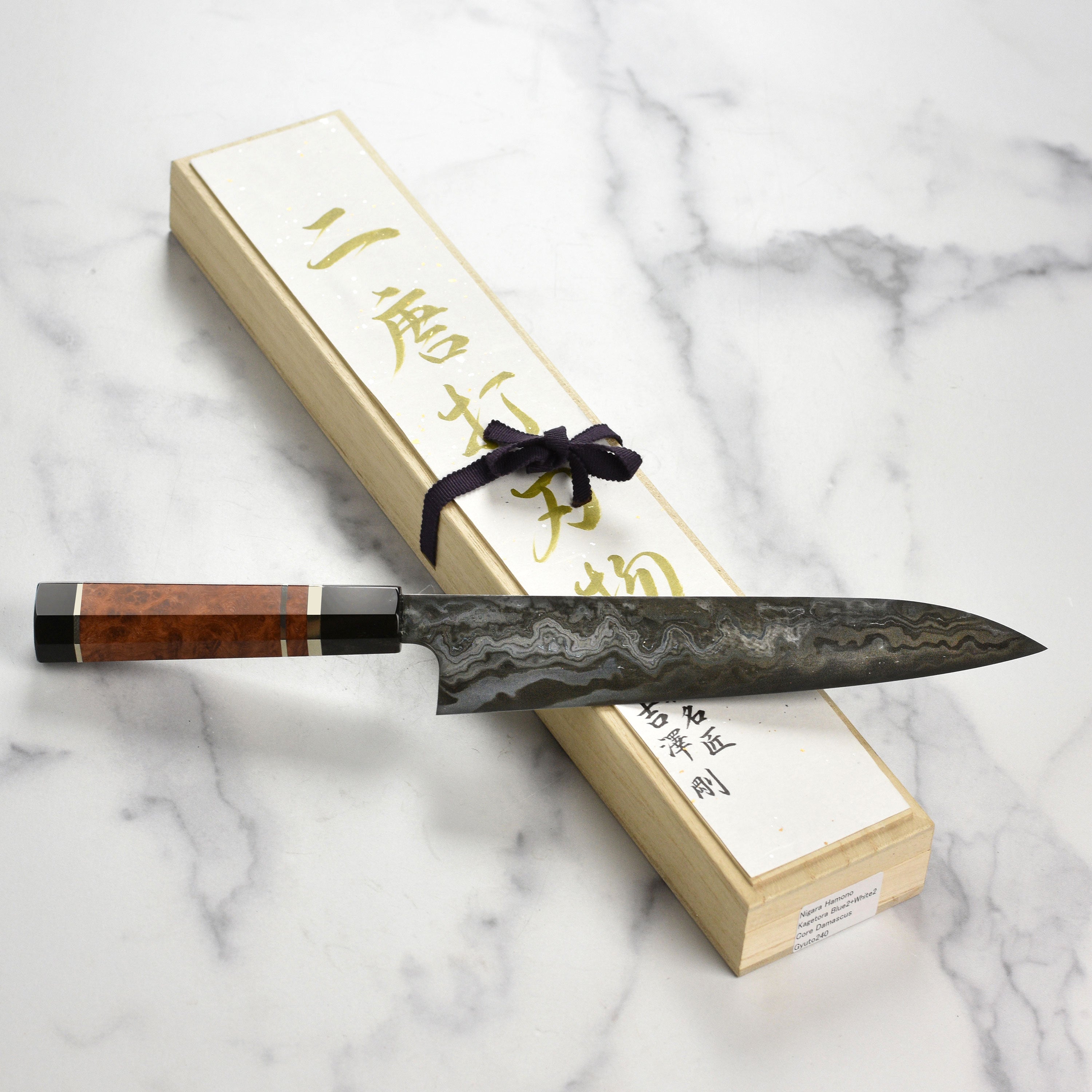 Side view of the 9.4" Japanese chef knife resting on a cutting board with fresh vegetables