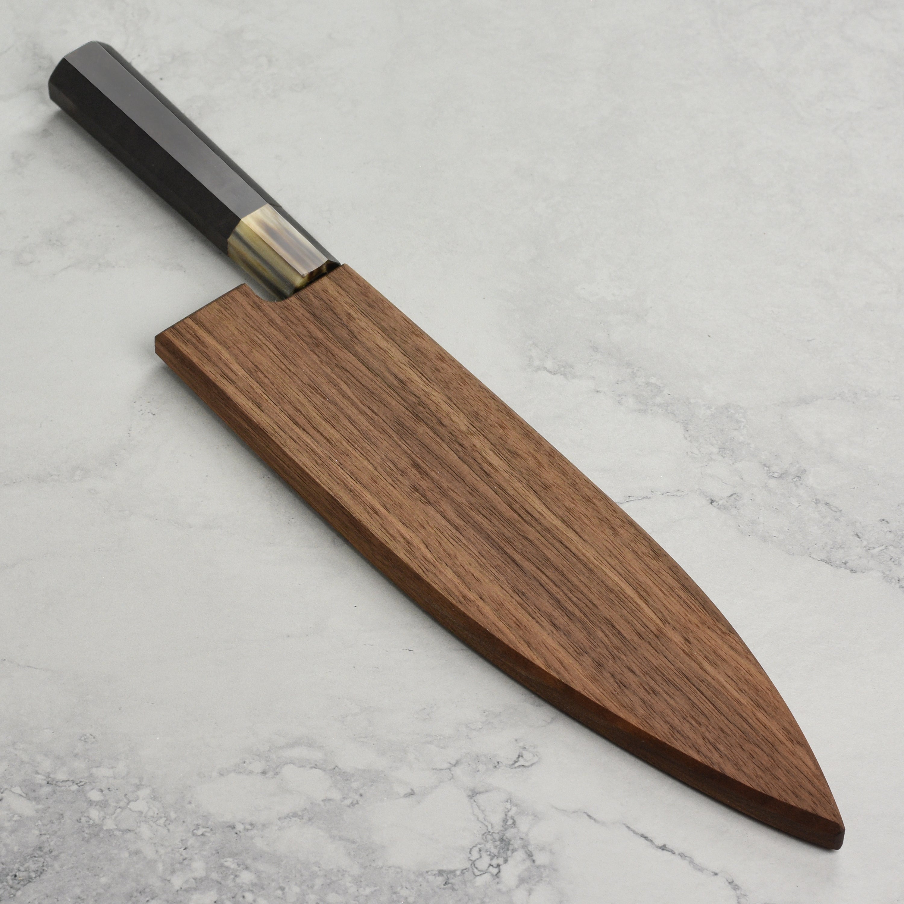 Side view of the walnut saya with a gyuto knife inserted, highlighting the secure magnetic hold