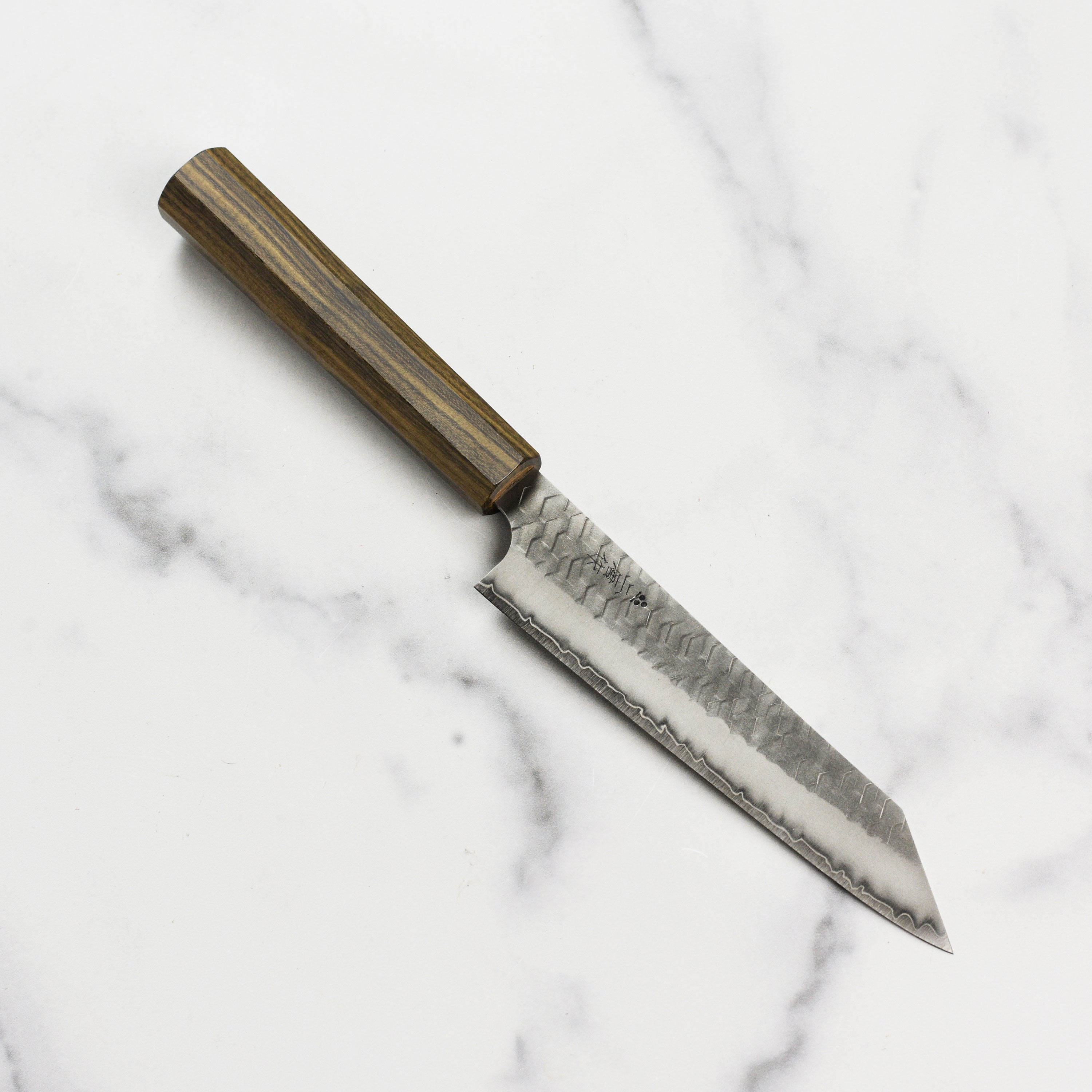Nigara SG2 Migaki Tsuchime Kiritsuke Petty knife on a wooden cutting board, highlighting its craftsmanship