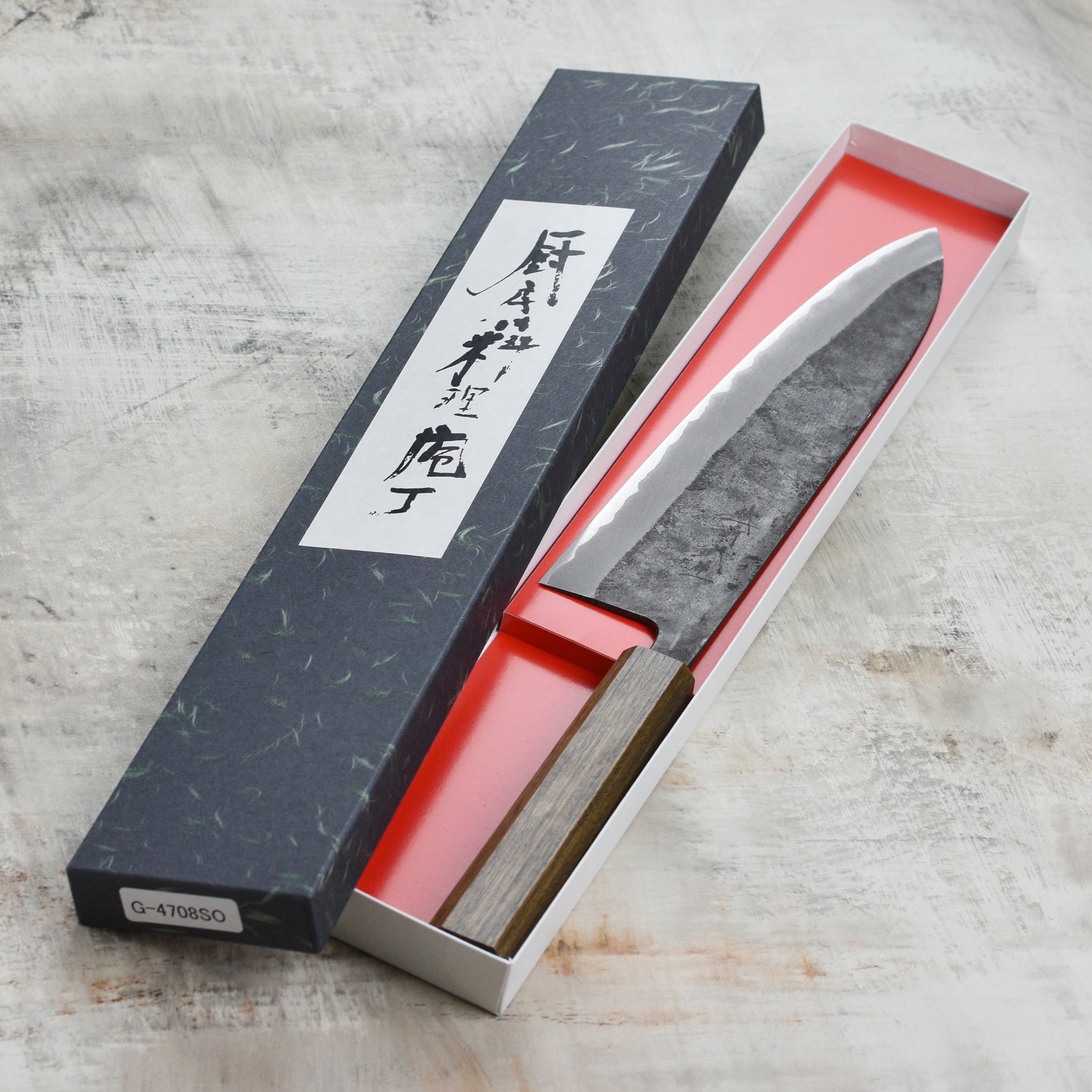 Shiro Kamo Aogami Super Gyuto from the side, showcasing its sharp blade and elegant design.