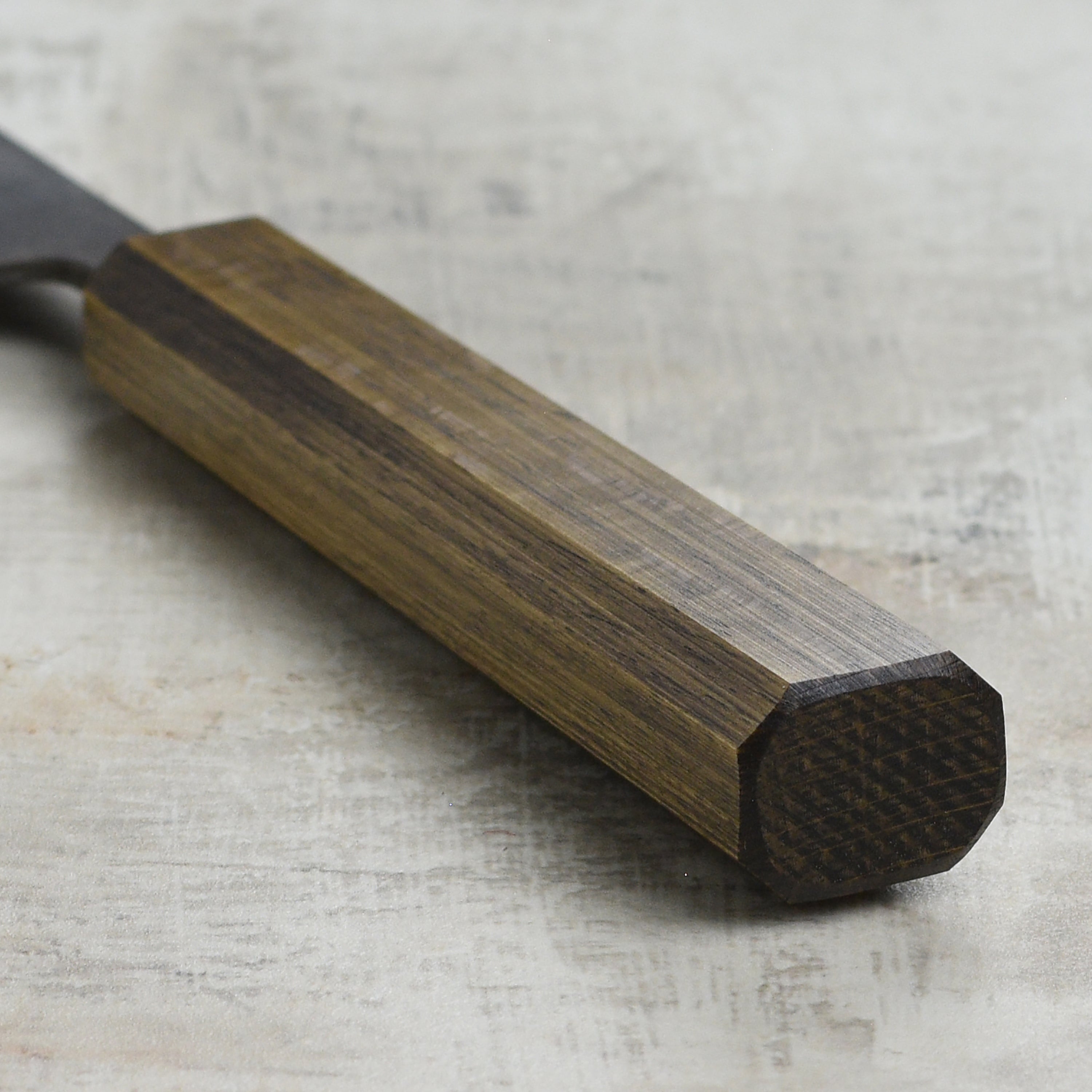 Close-up of the Shiro Kamo Aogami Sujihiki Knife on a wooden cutting board.