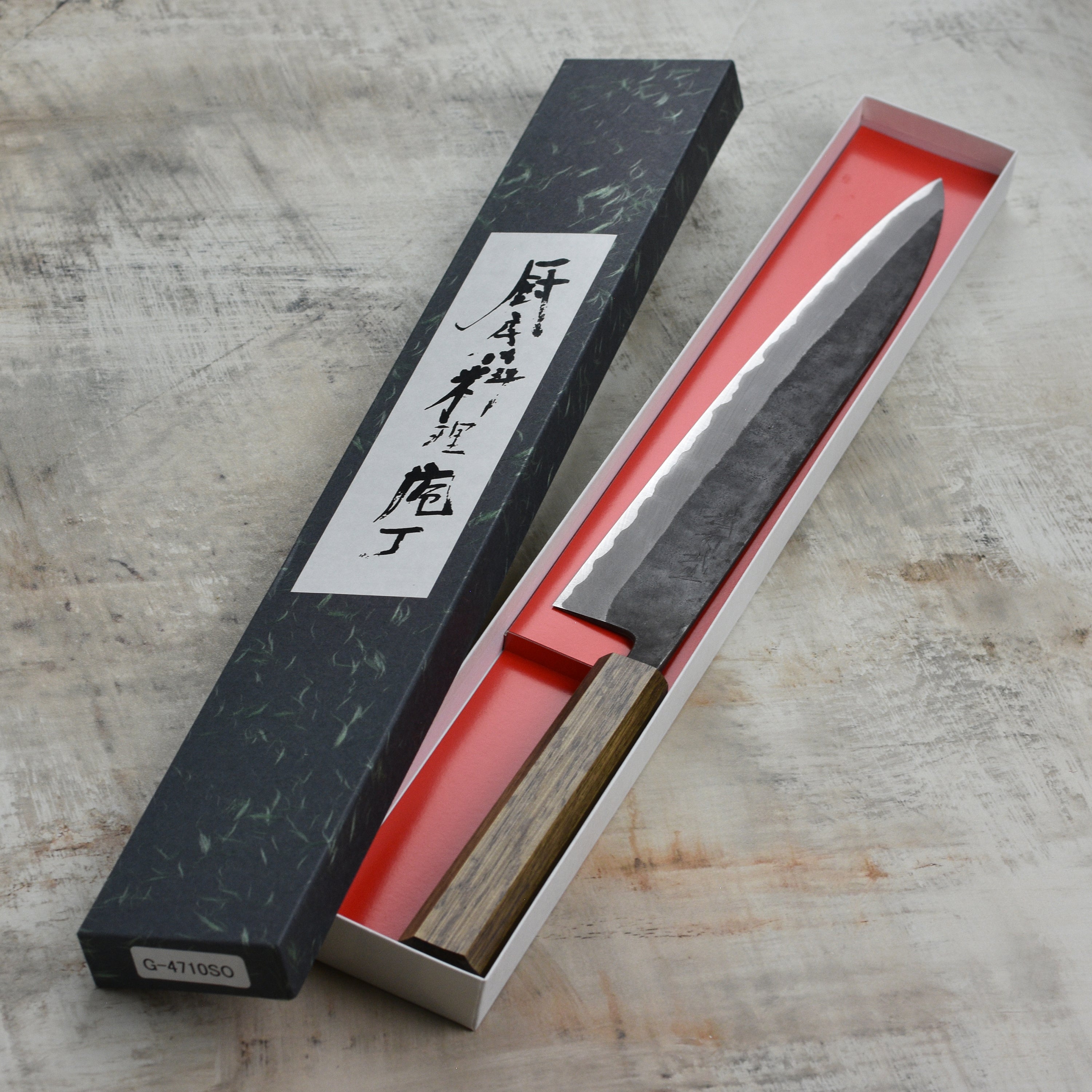 Shiro Kamo Aogami Sujihiki Knife showcasing its sharp edge and Kurouchi finish.