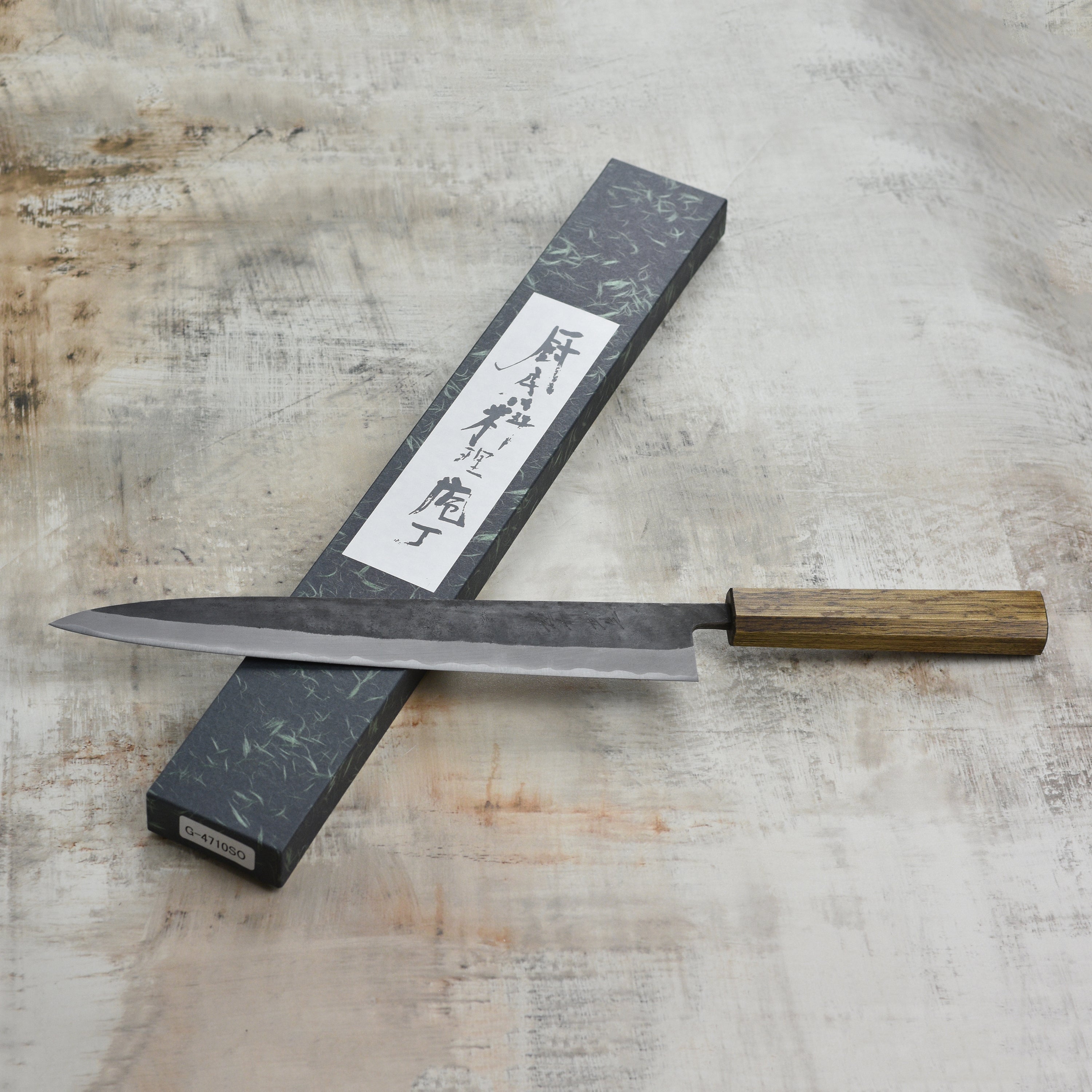 Shiro Kamo Aogami Sujihiki Knife showcasing its sharp edge and Kurouchi finish.