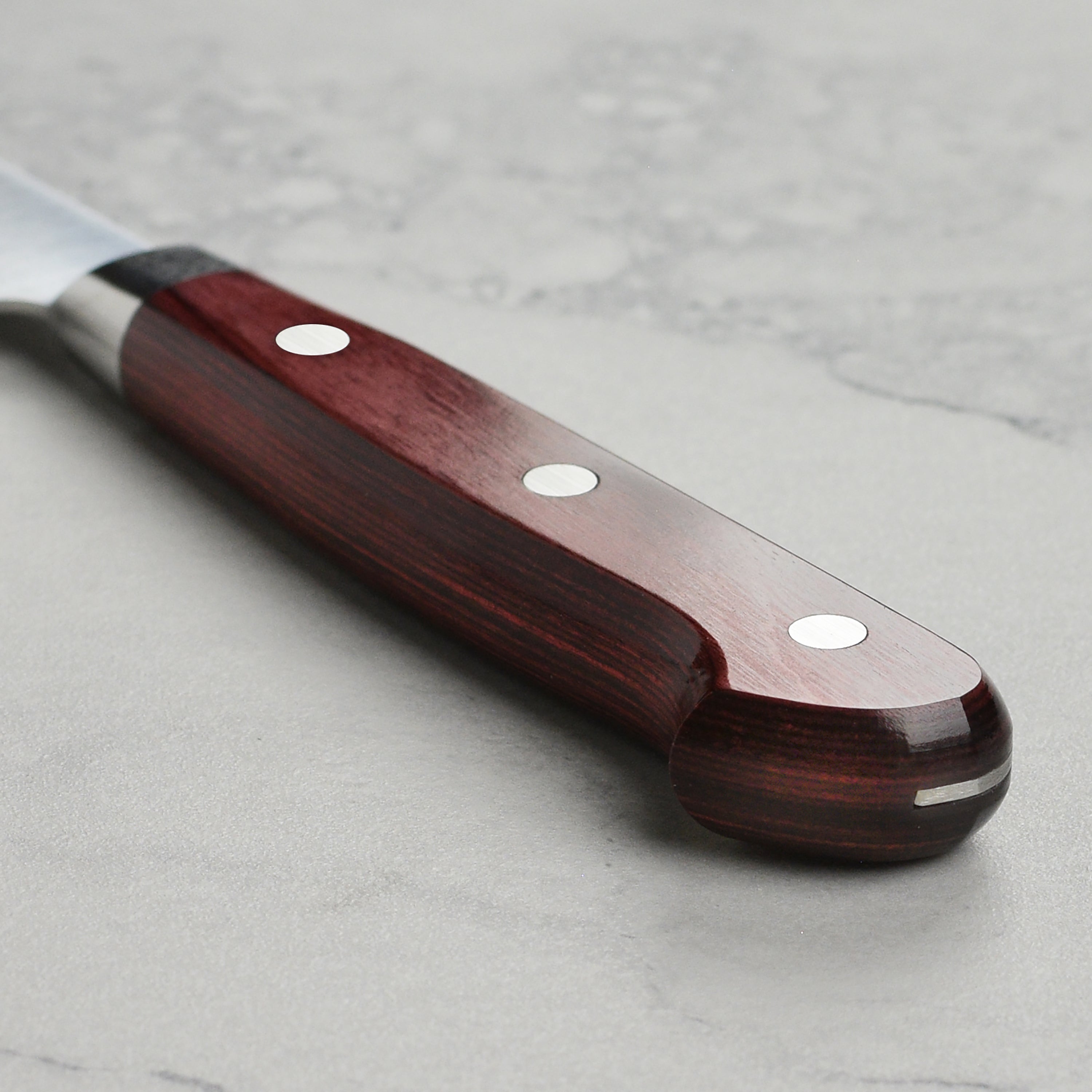 Close-up of the Takamura SG2 petty knife in action, slicing fresh vegetables.