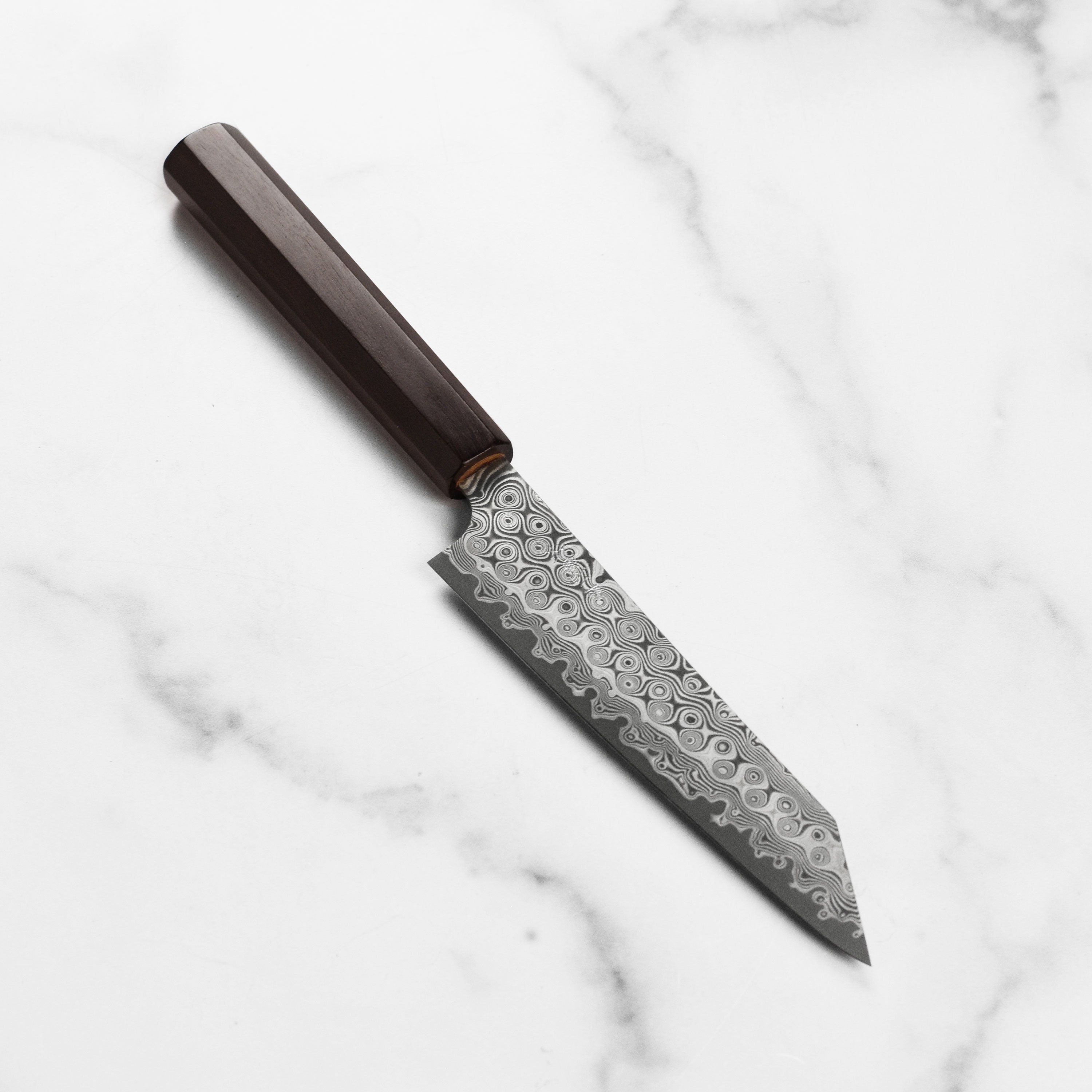 Premium SG2 Damascus Kiritsuke Petty Knife from an angle, showcasing its sharp blade and handle design.