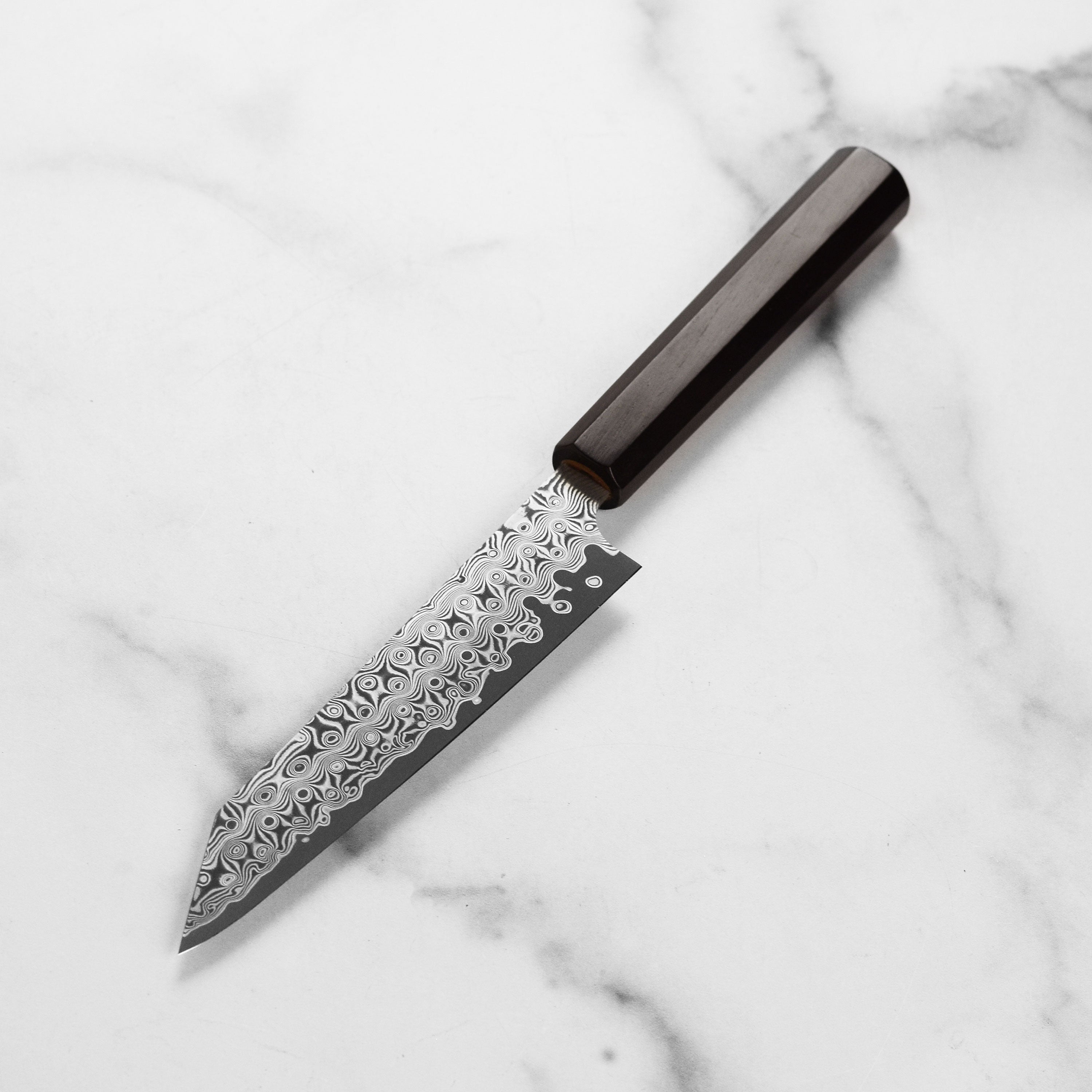 Detailed view of the blade of the best Japanese Damascus chef knife for home use, highlighting its unique pattern.