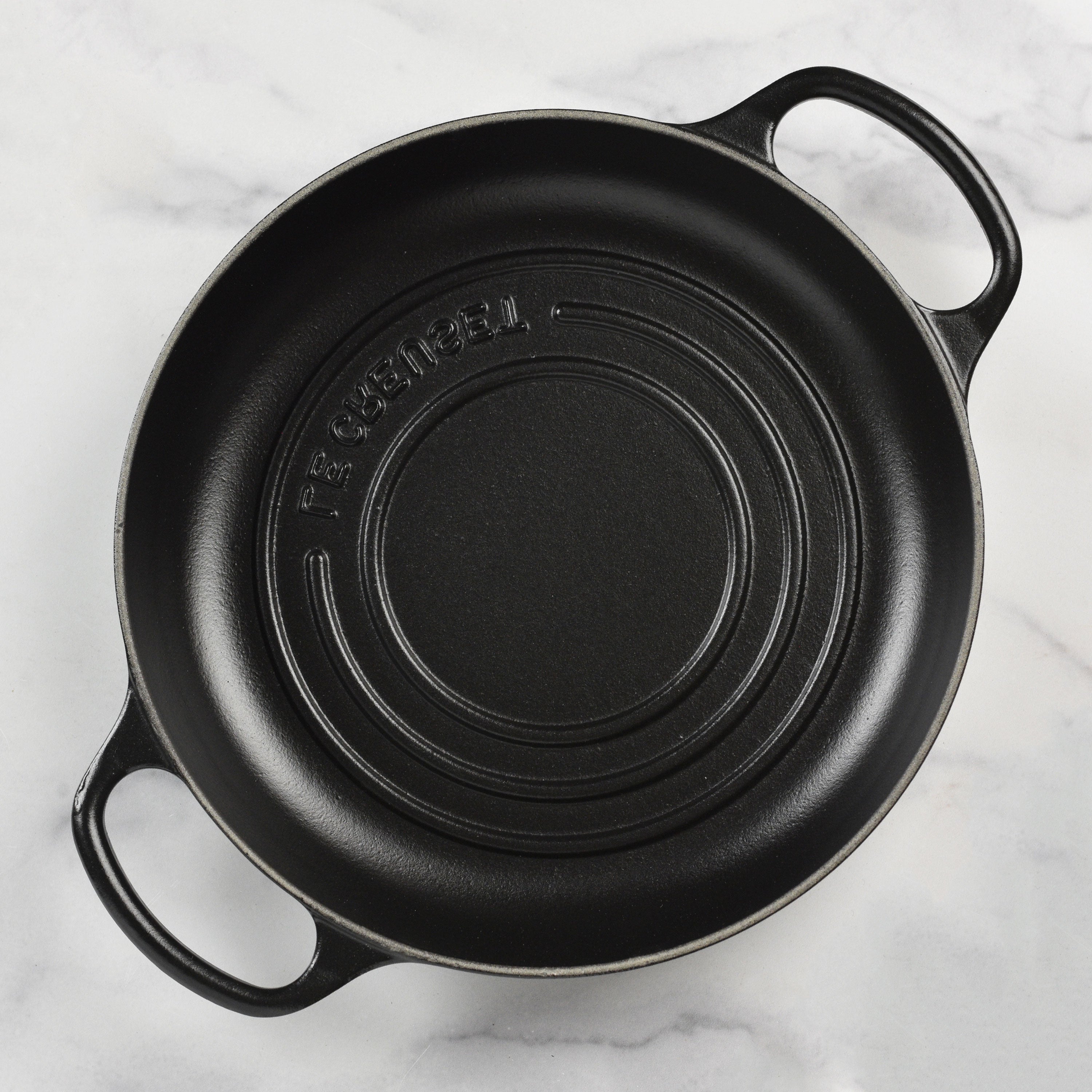 Close-up of Le Creuset cast iron bread oven with lid on, highlighting its enamel coating and ergonomic handles