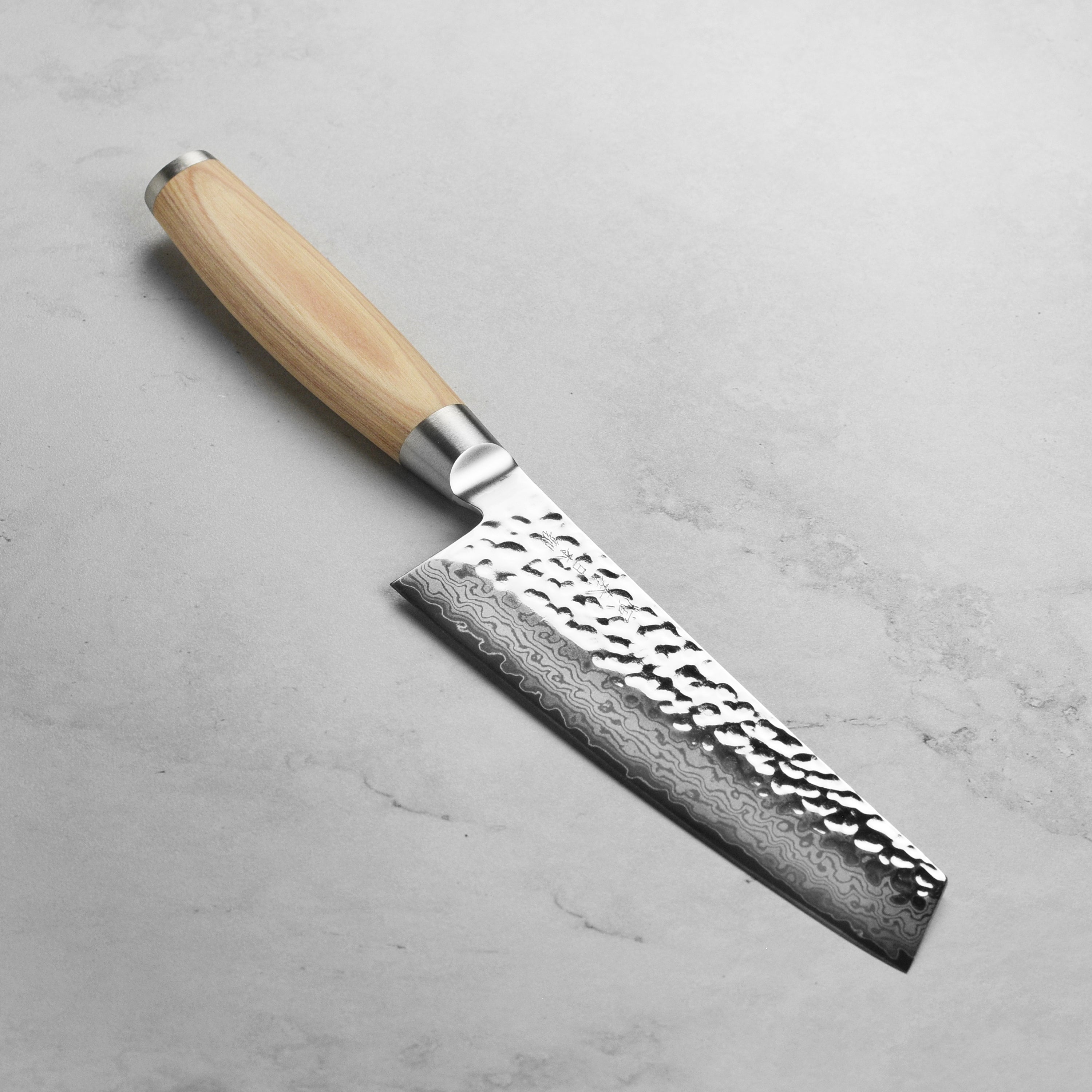 Seki Steel Damascus Prep Knife resting on a wooden cutting board, highlighting its blade and Pakkawood handle.