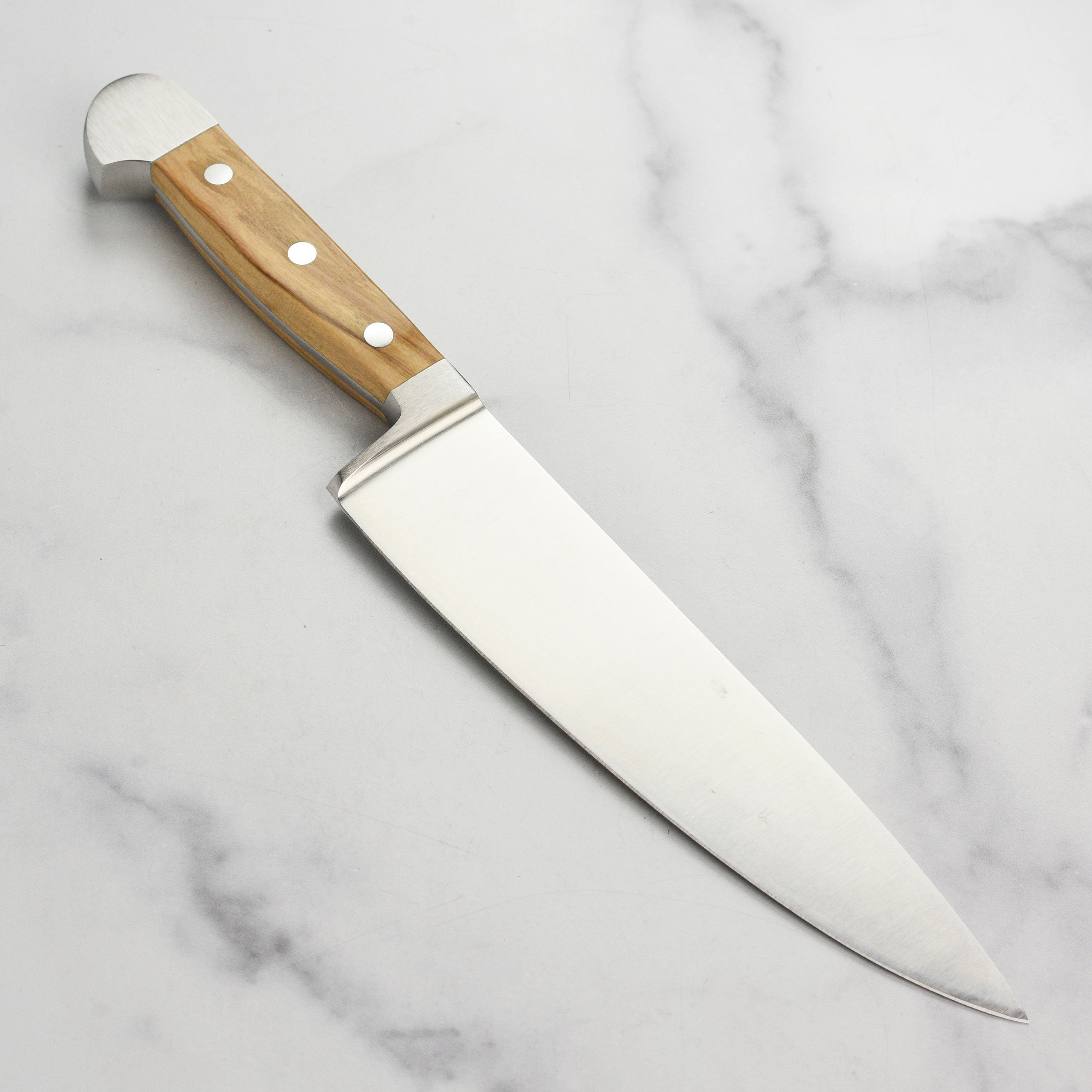 Close-up of the Gude Alpha Olive blade showing the high carbon steel finish and craftsmanship.