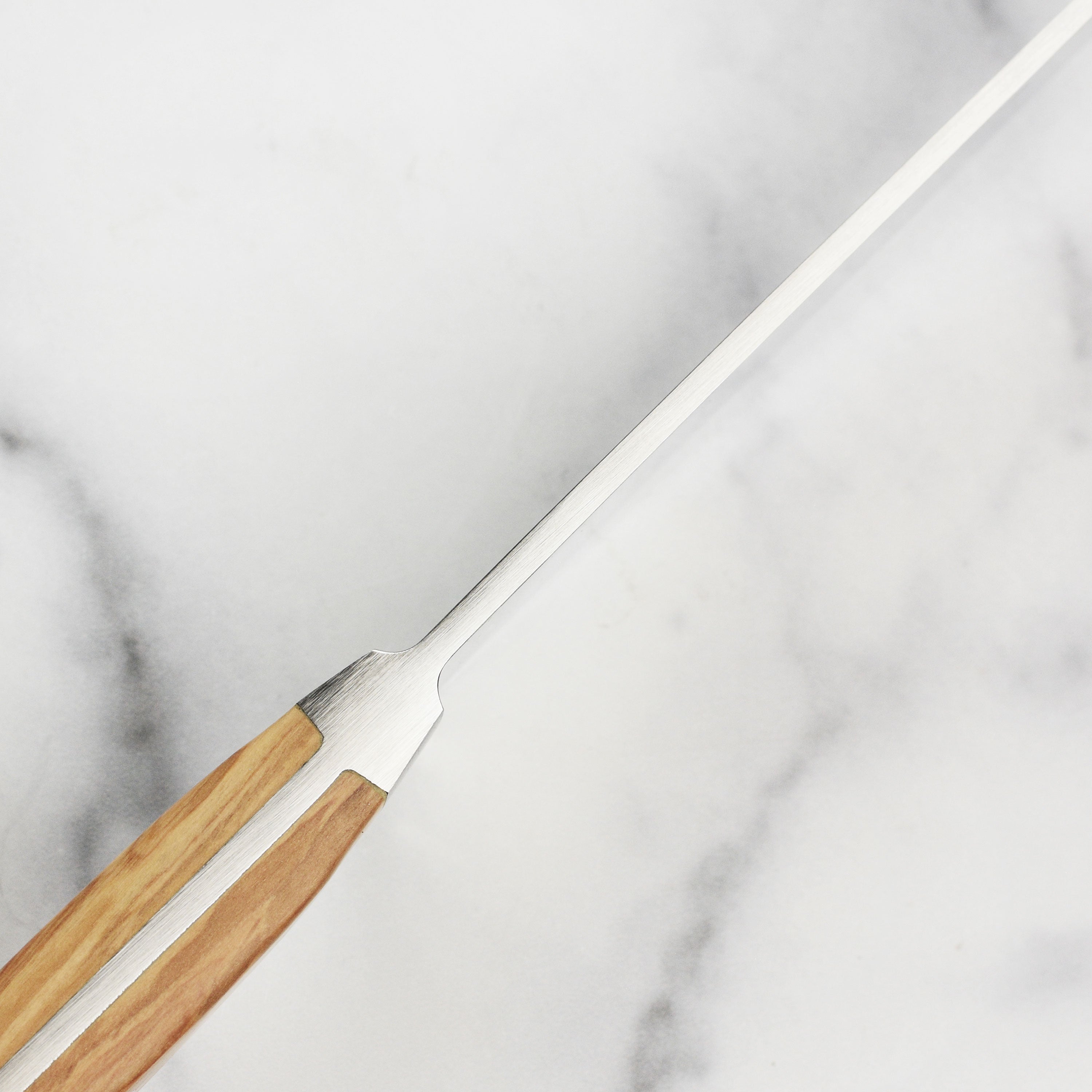 Gude Alpha Olive knife in use, slicing fresh vegetables with precision and ease.