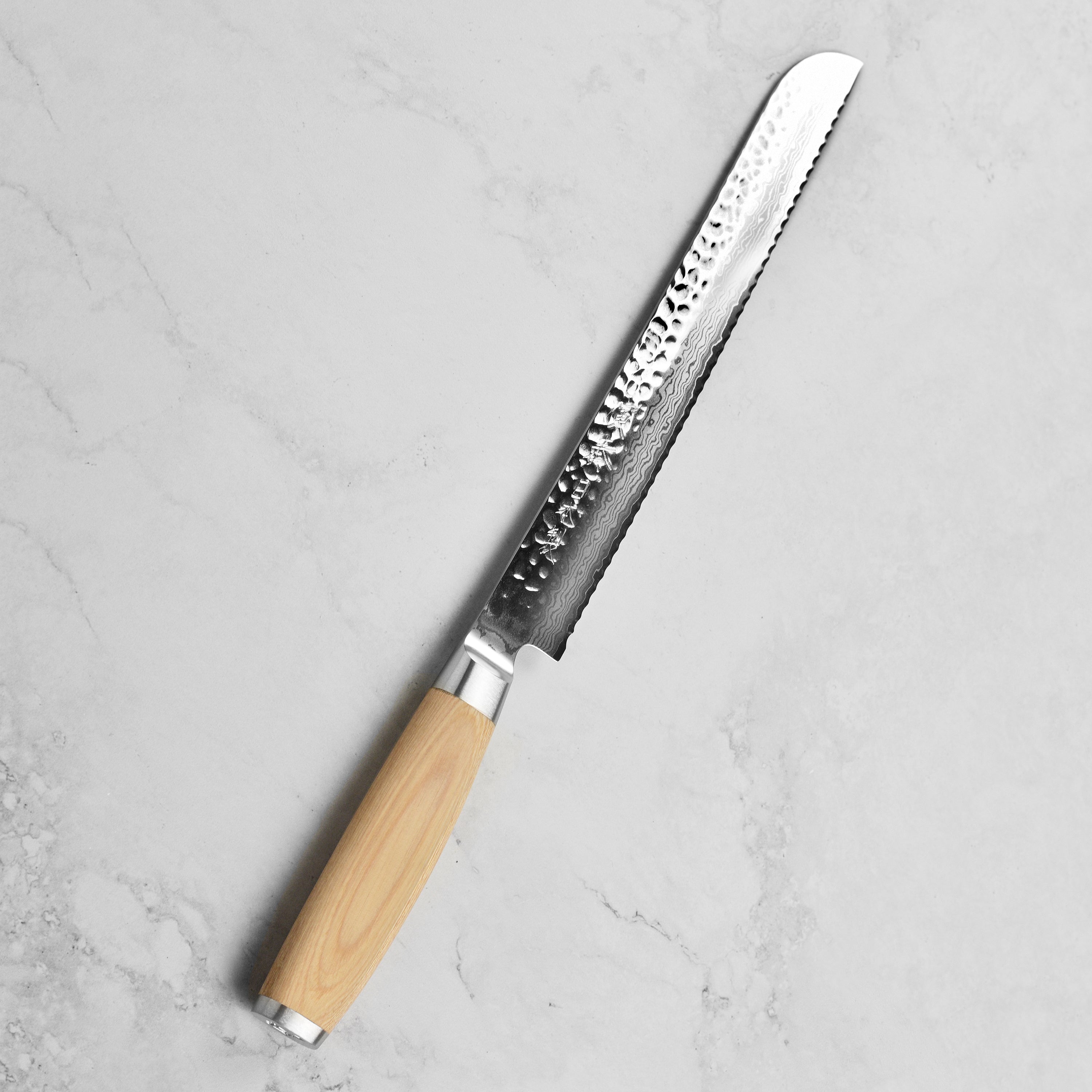Slicing crusty bread with the VG-10 steel core bread knife in a professional kitchen