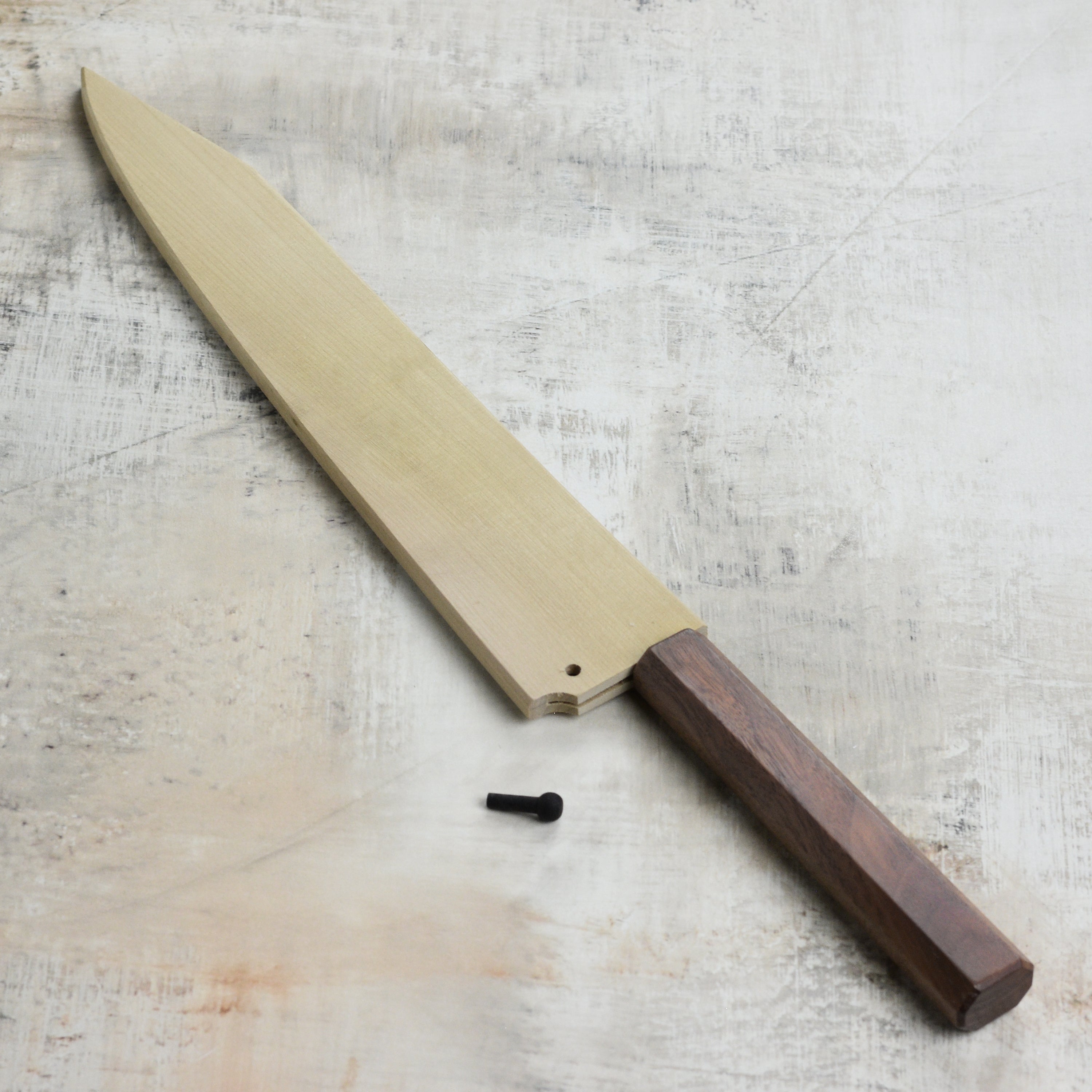 Front view of the Kurosaki Saya sheath on a Sujihiki knife in a kitchen setting