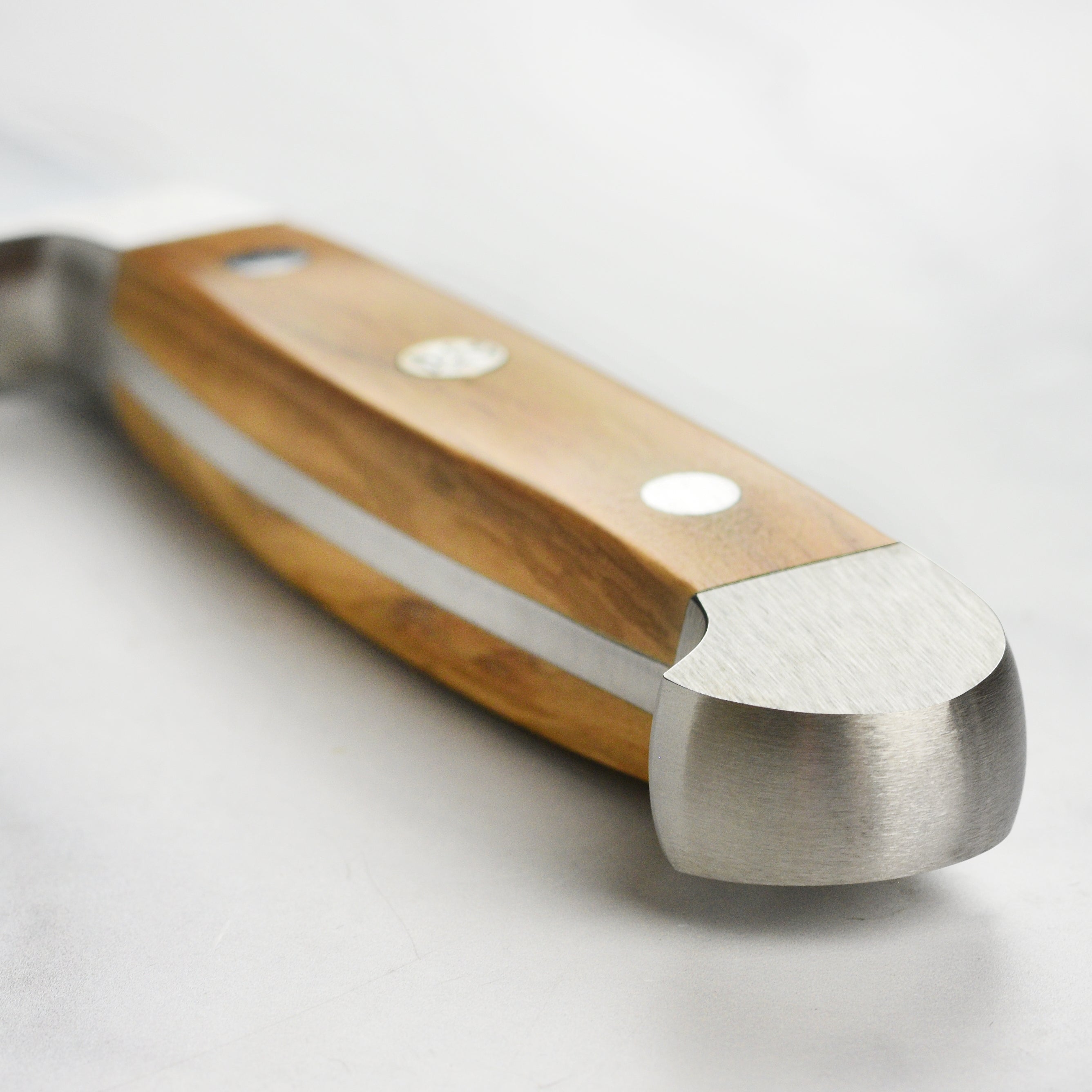 Chef slicing crusty bread with the ambidextrous bread knife, highlighting ergonomic design