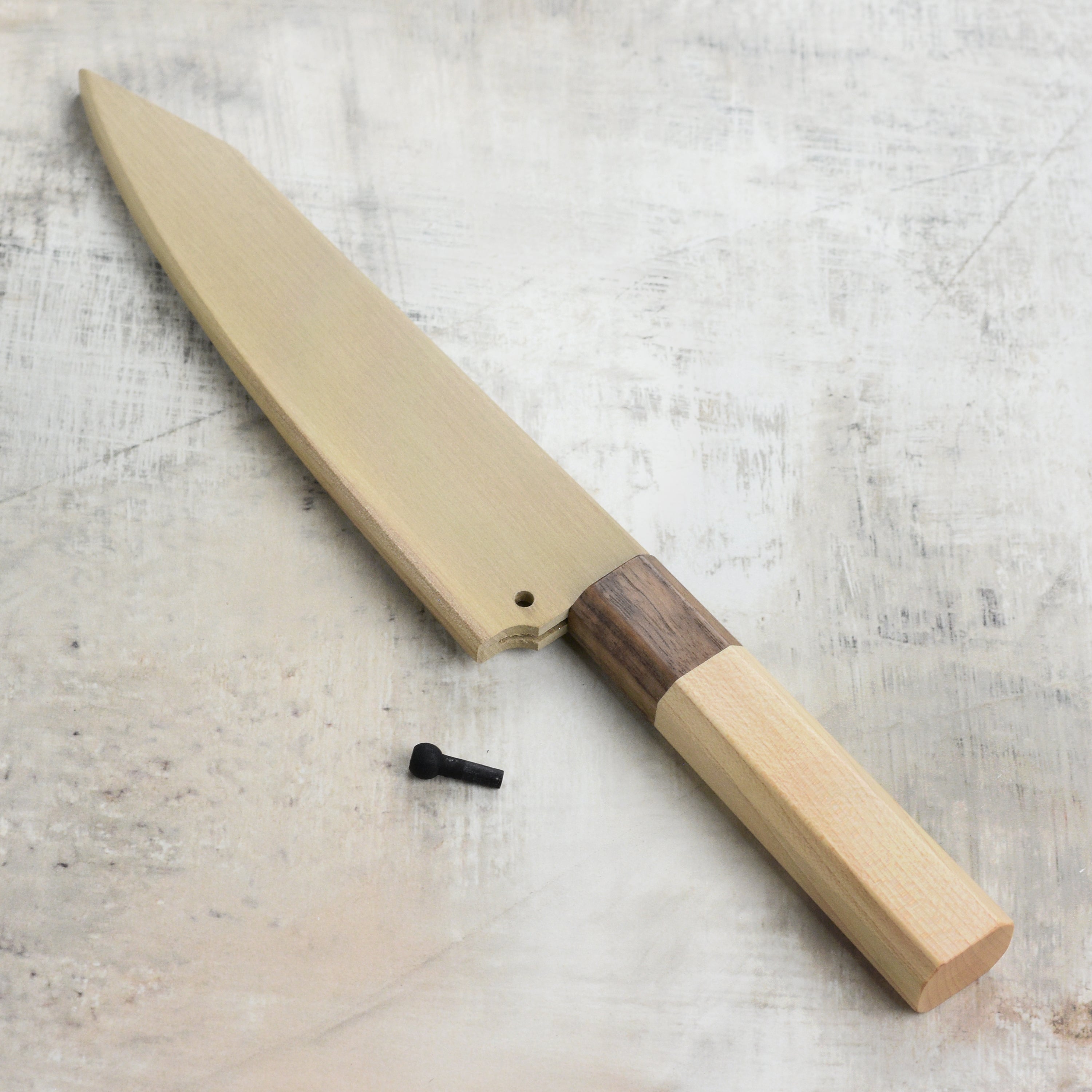 Japanese petty knife safely stored inside Kurosaki Saya with smooth wood grain finish