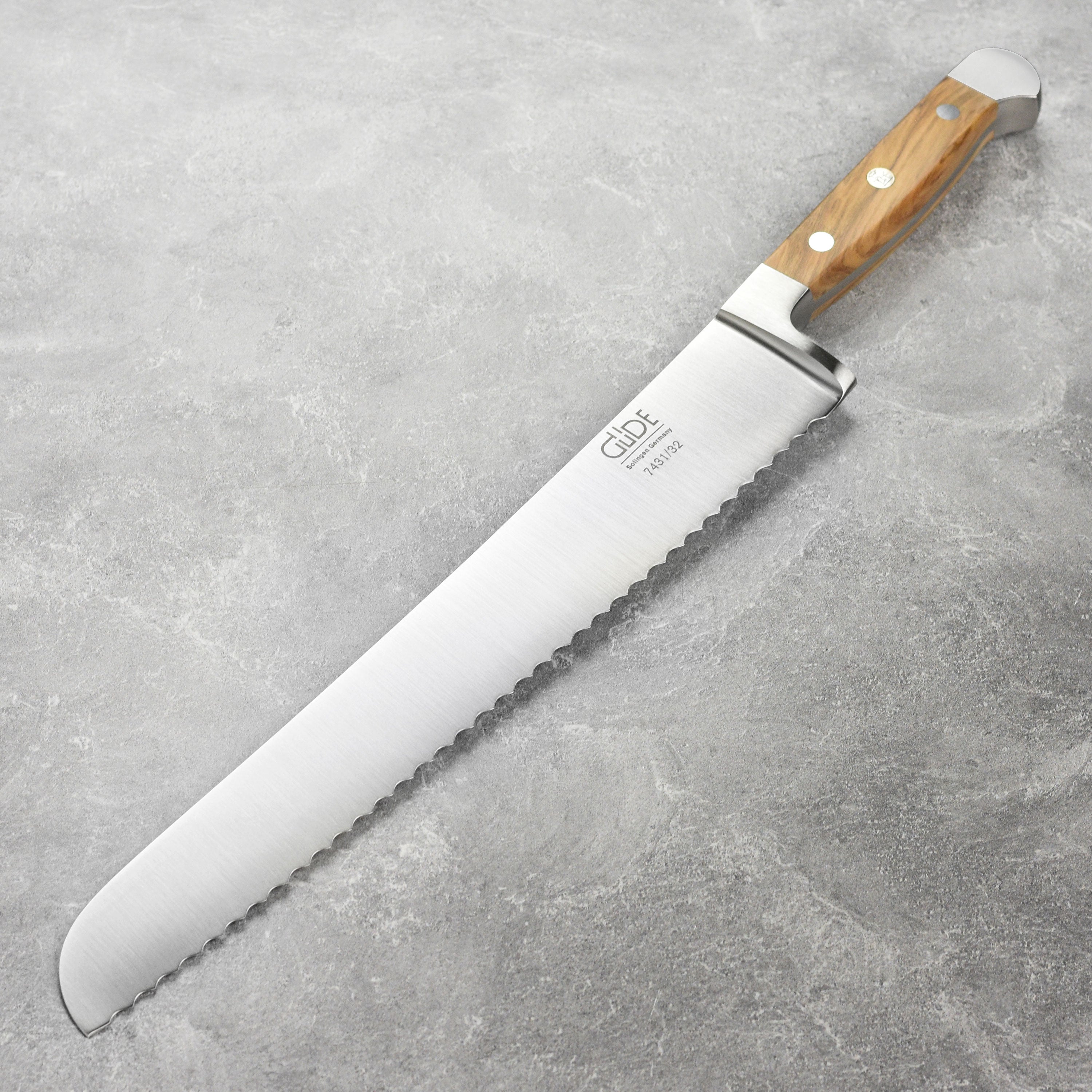 Close-up of serrated bread knife with olive wood handle for slicing crusty bread