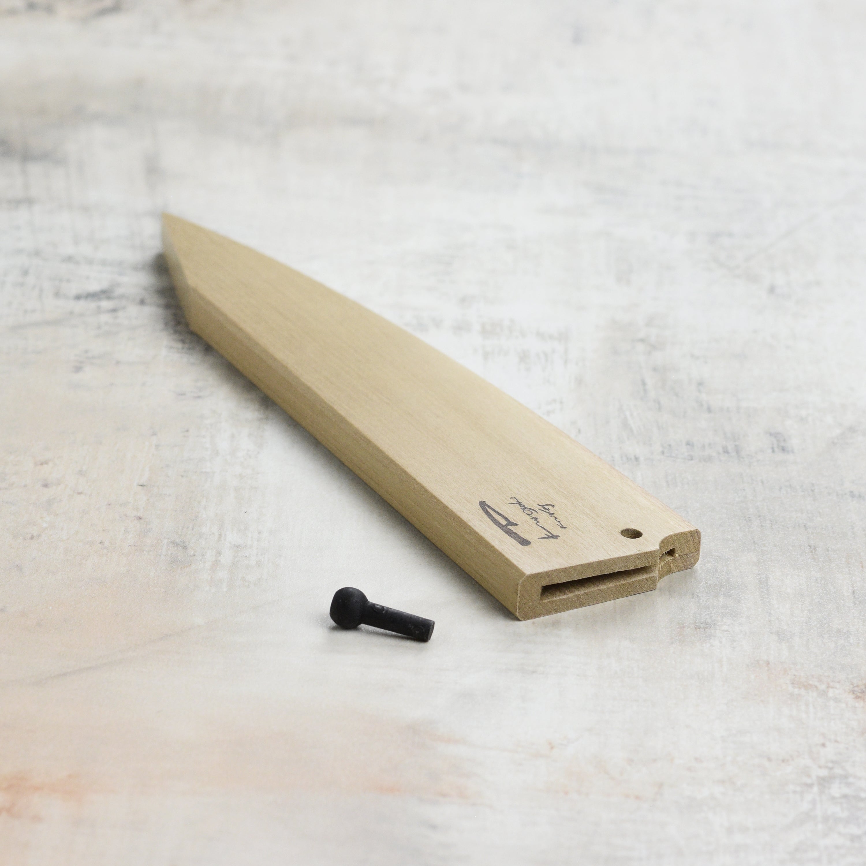 Side angle of Kurosaki Saya sheath for 5.9" petty knife placed next to its blade