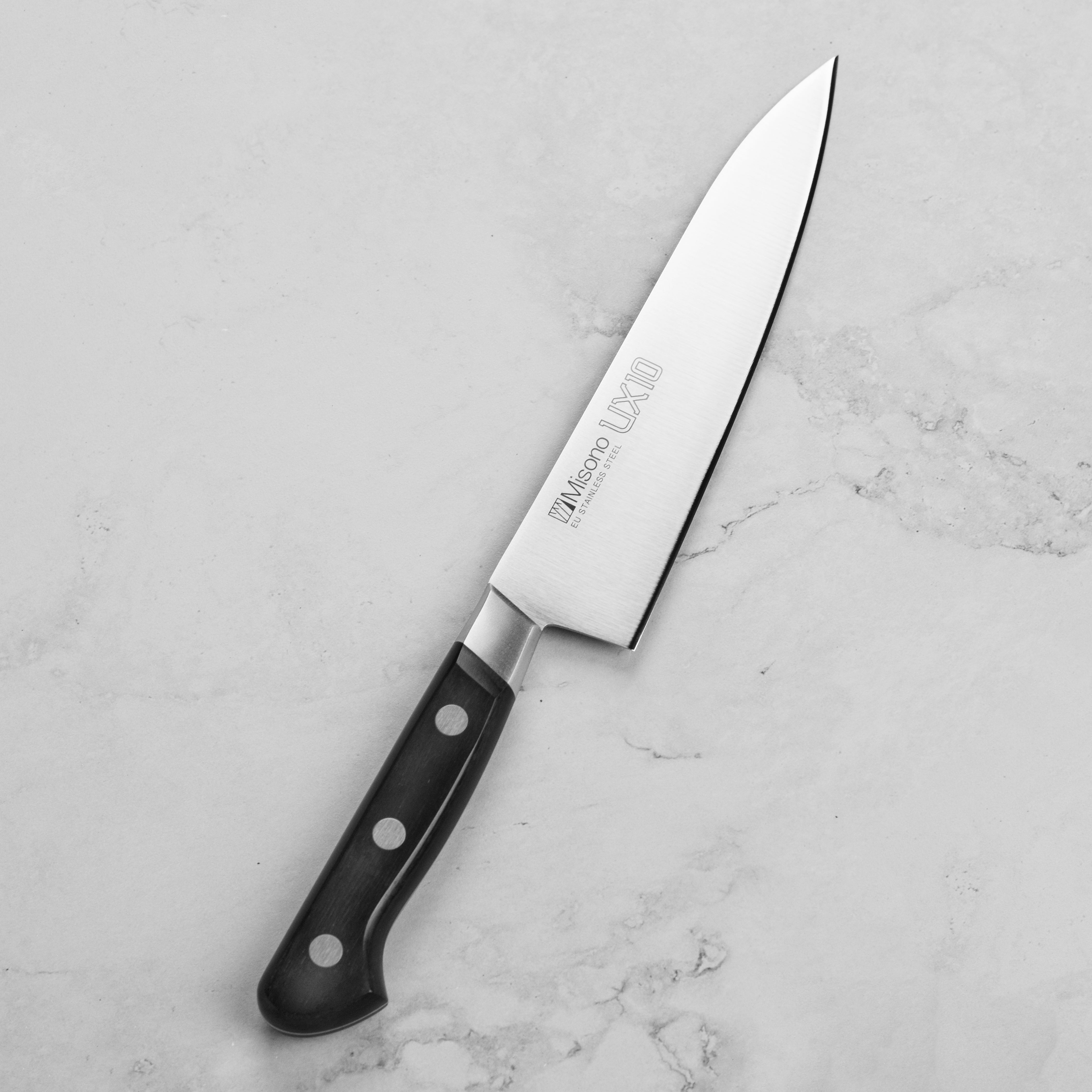 Display of the Misono UX10 knife with its sheath, highlighting the craftsmanship and materials.
