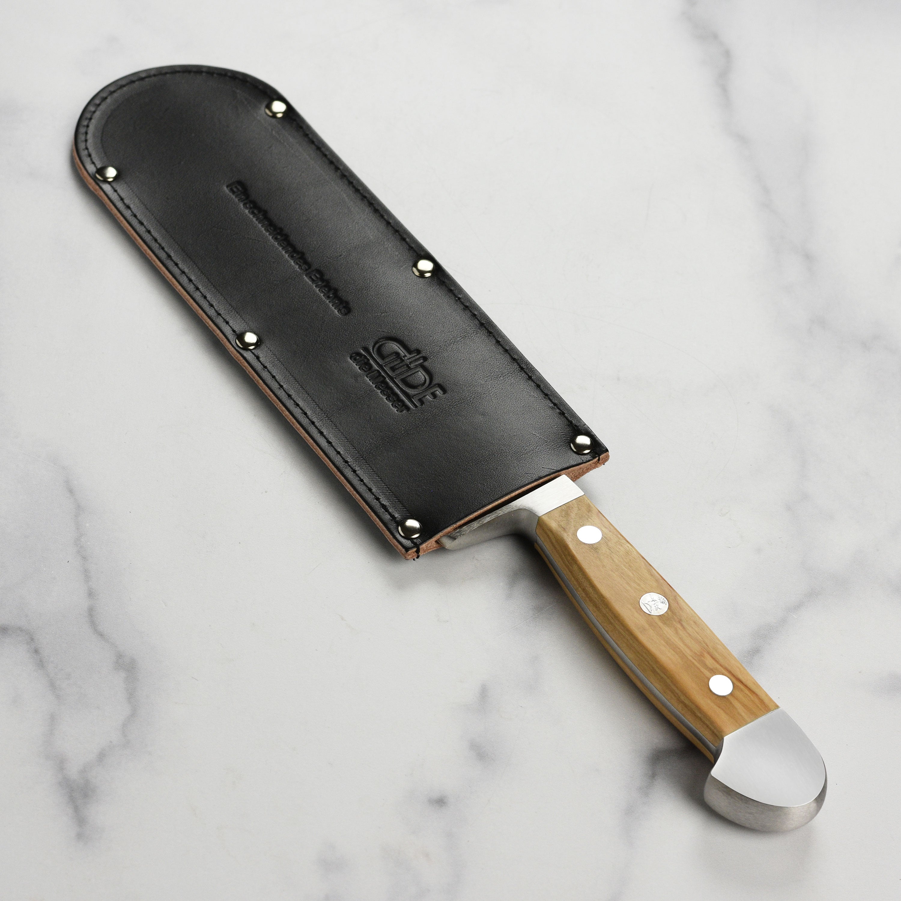 Full view of premium cowhide sheath laid next to German chef knife