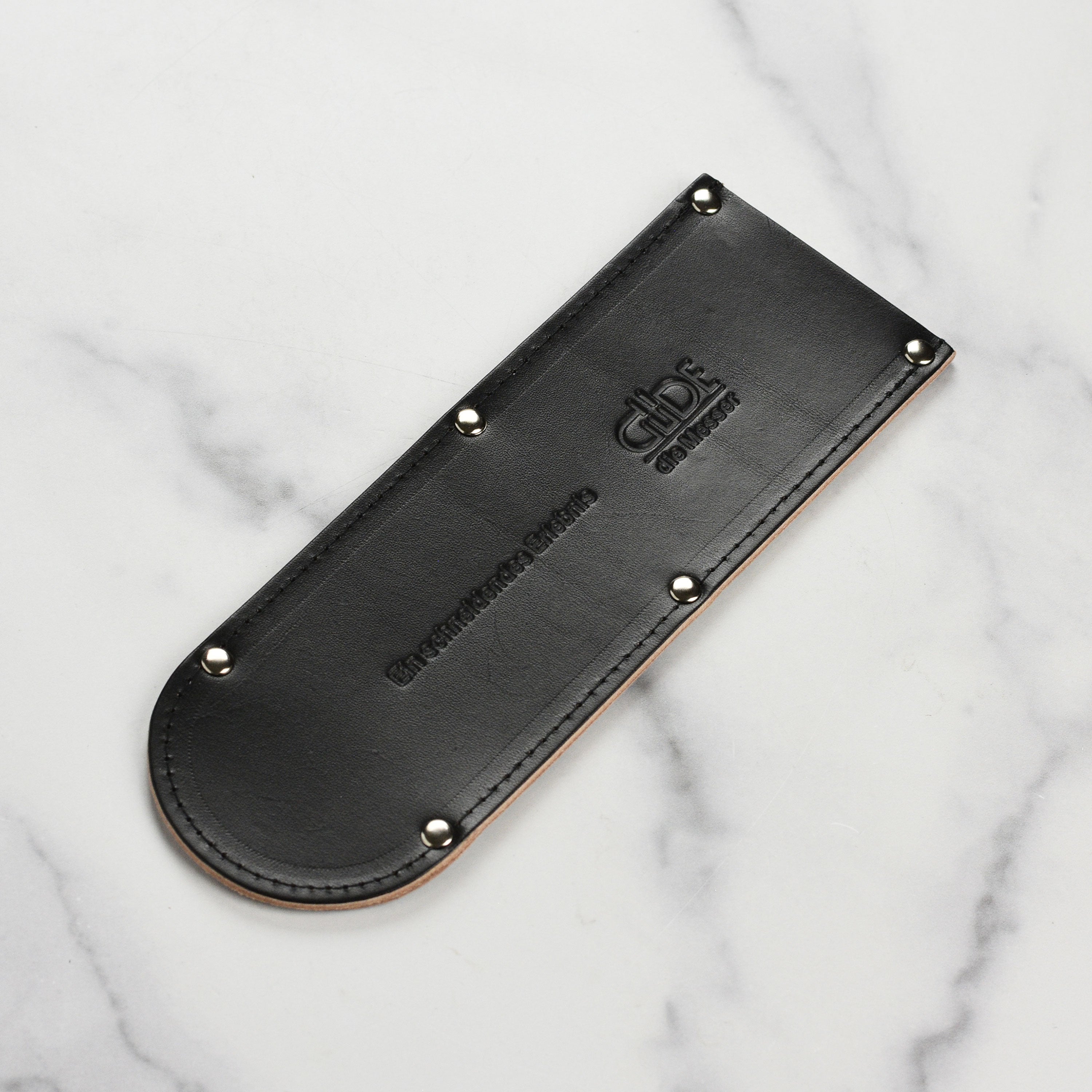 Angled close-up of leather blade protector showing stitching and texture