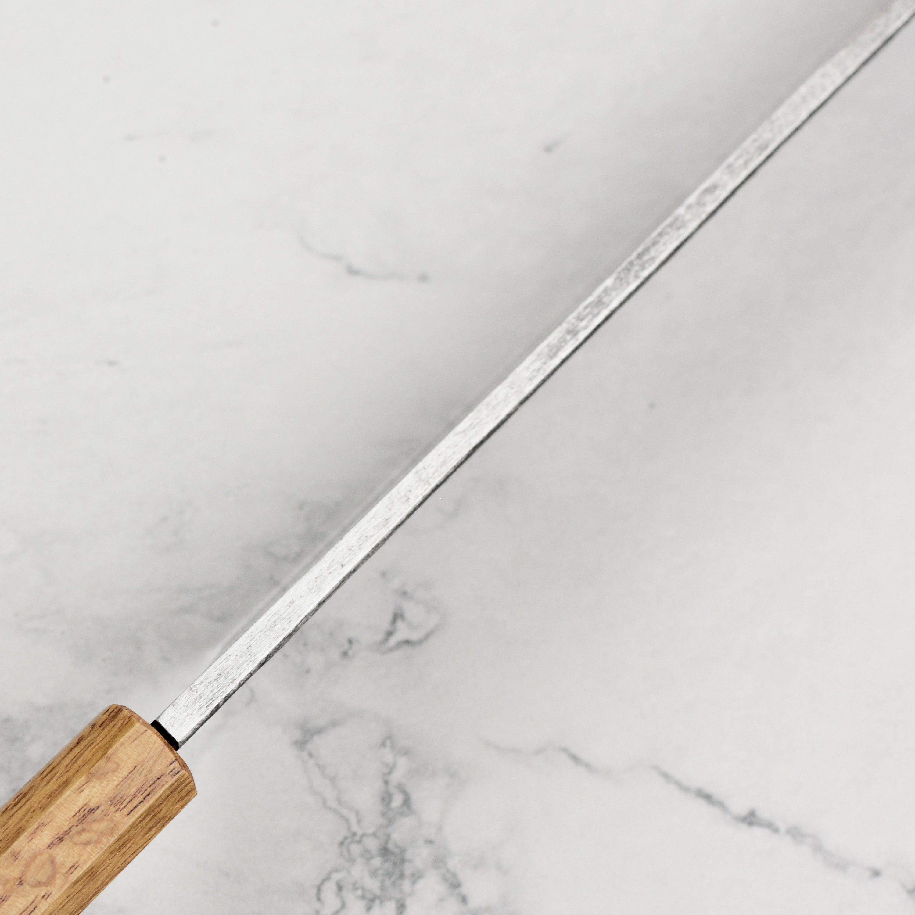 Professional chef using the Takayuki single bevel knife for sushi preparation, demonstrating its slicing capability.