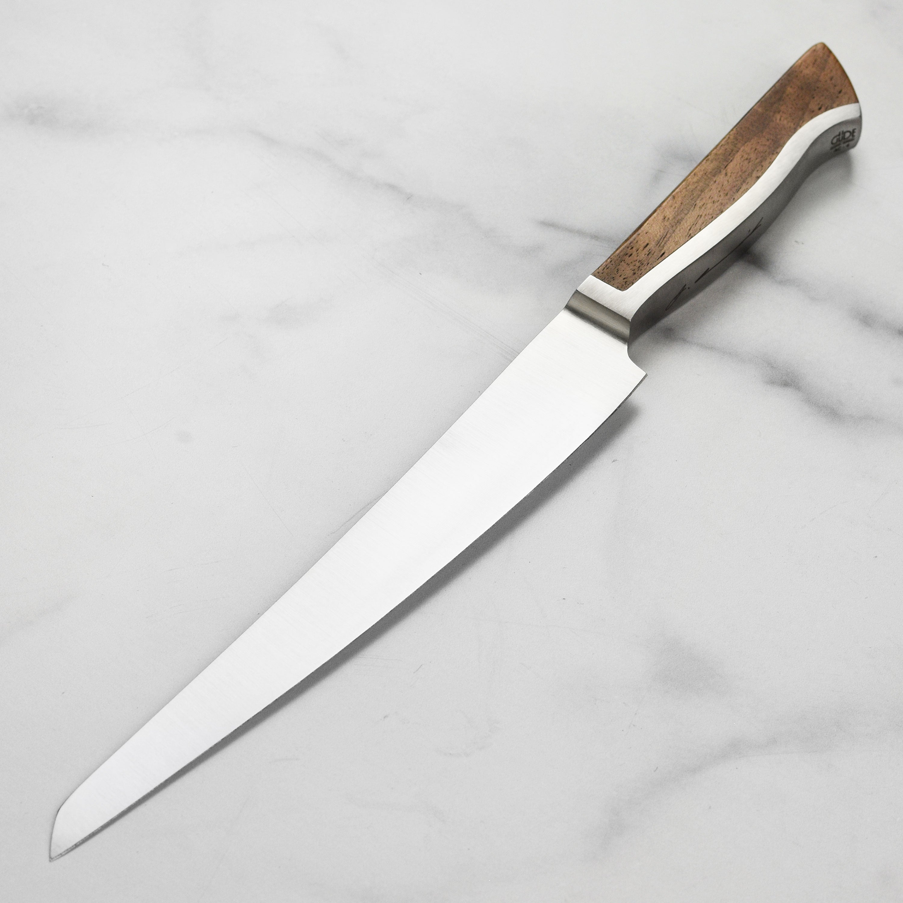 Gude Caminada slicing knife with walnut handle in a kitchen setting.