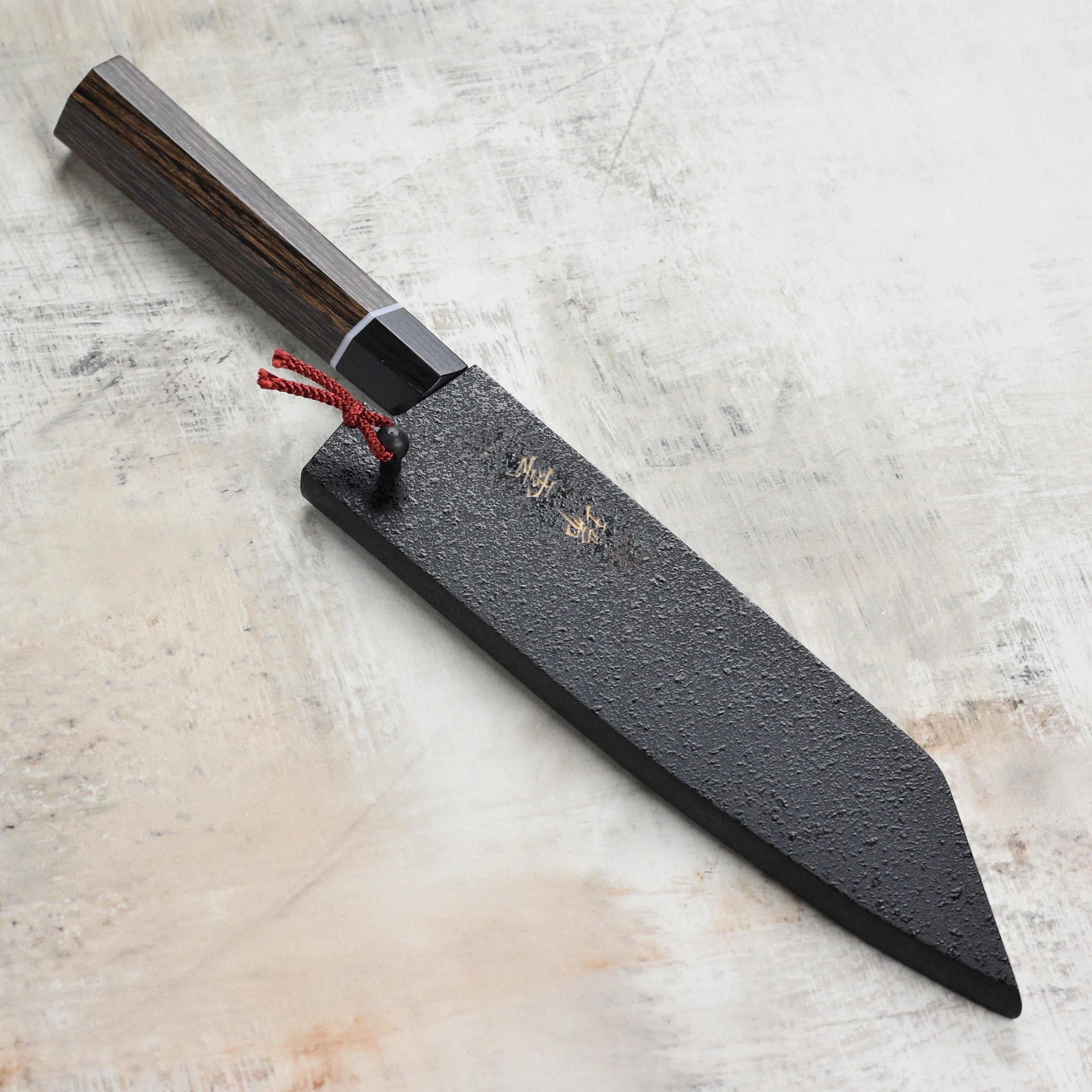 Close-up of the engraved ZUIUN logo on the high-quality Japanese knife saya, highlighting craftsmanship.