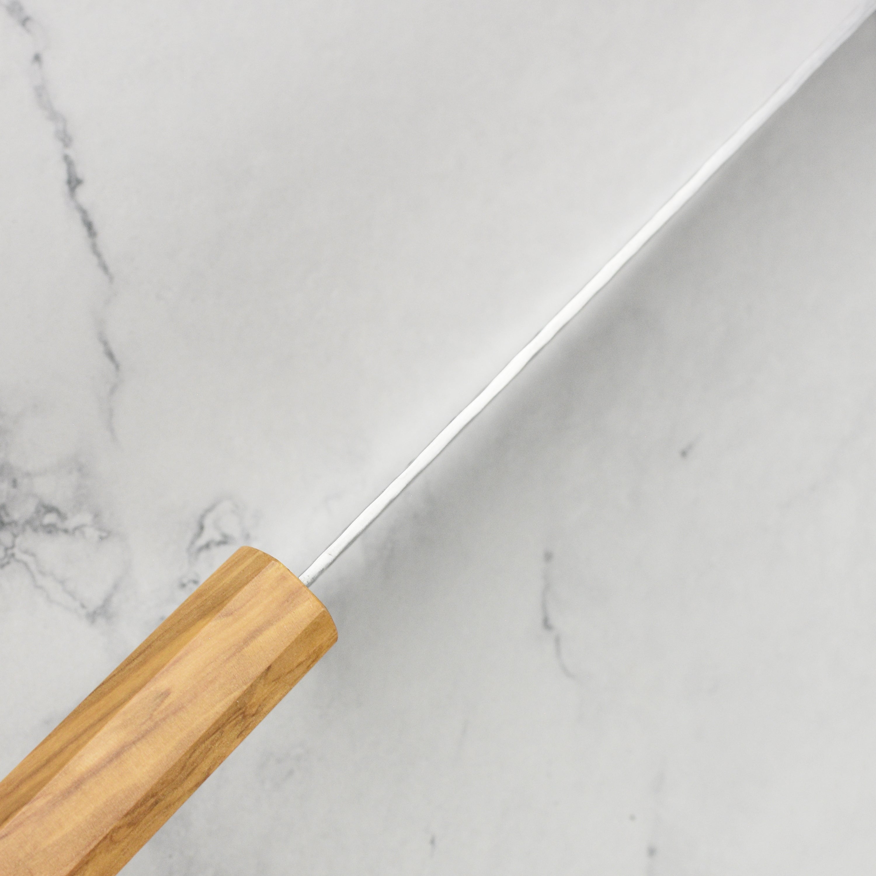 Premium Olivewood Nakiri Knife in action, slicing fresh vegetables on a wooden cutting board.