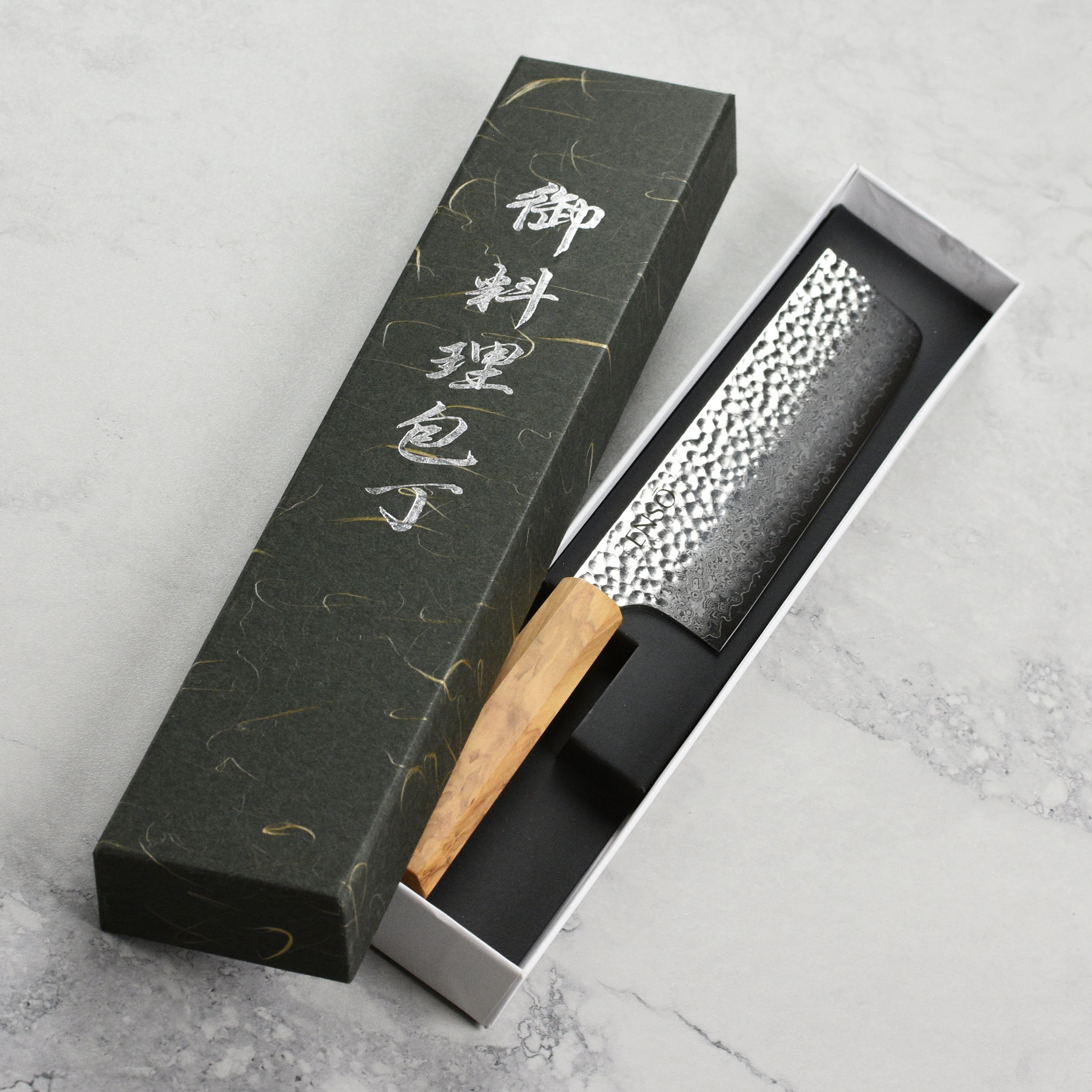 Close-up of the Premium Olivewood Nakiri Knife showcasing its sharp blade and beautiful grain.