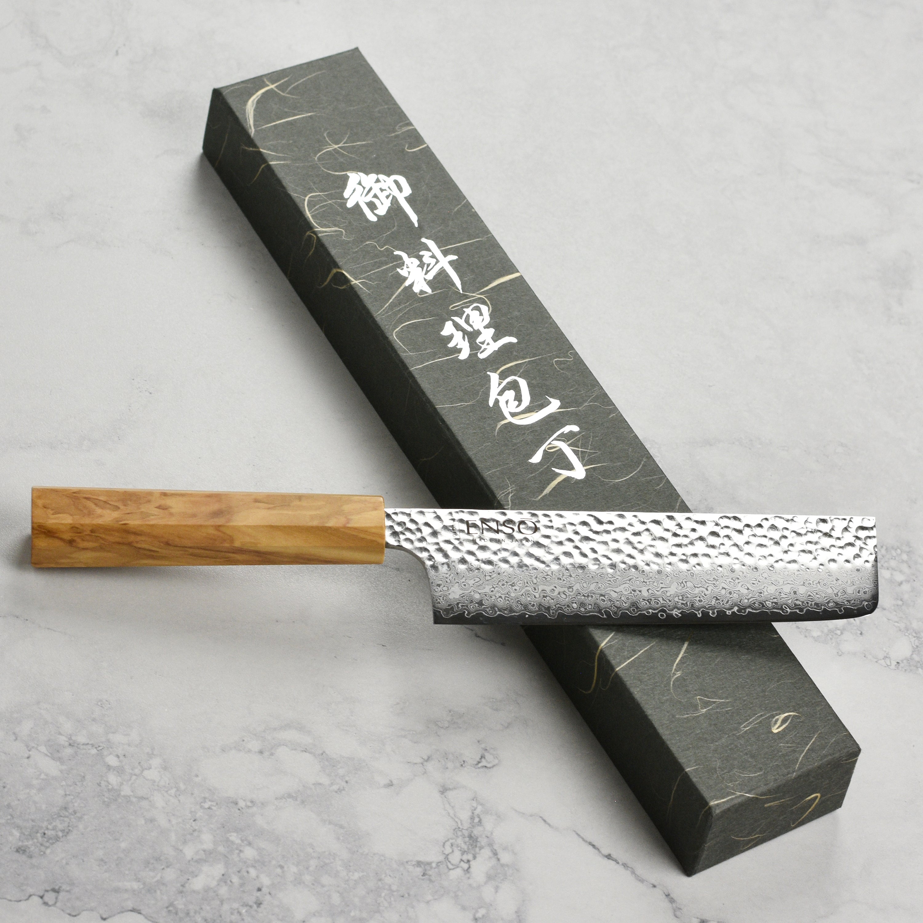 Close-up of the Premium Olivewood Nakiri Knife showcasing its sharp blade and beautiful grain.