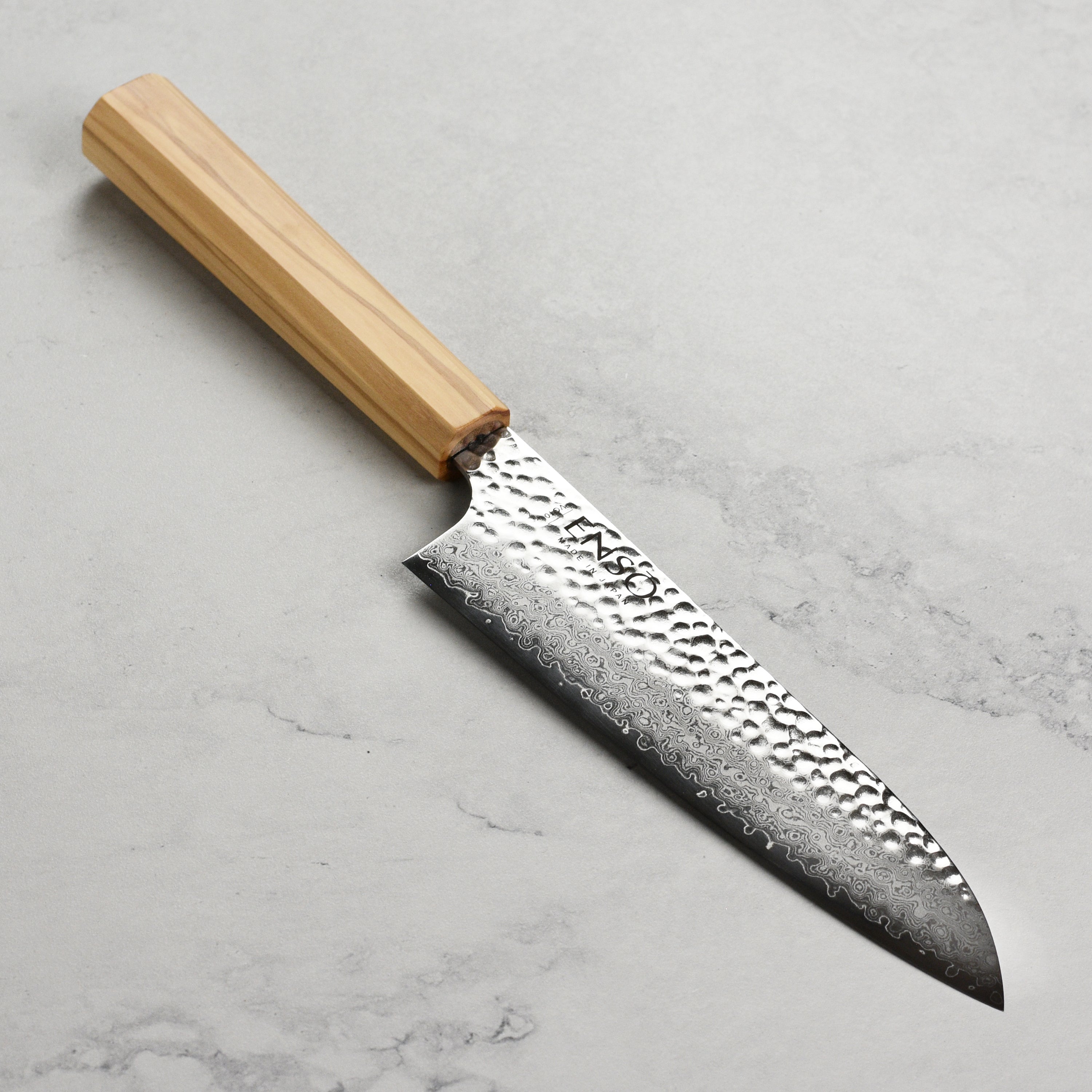 Enso Olivewood Santoku knife from above, highlighting the blade's sharpness and craftsmanship.