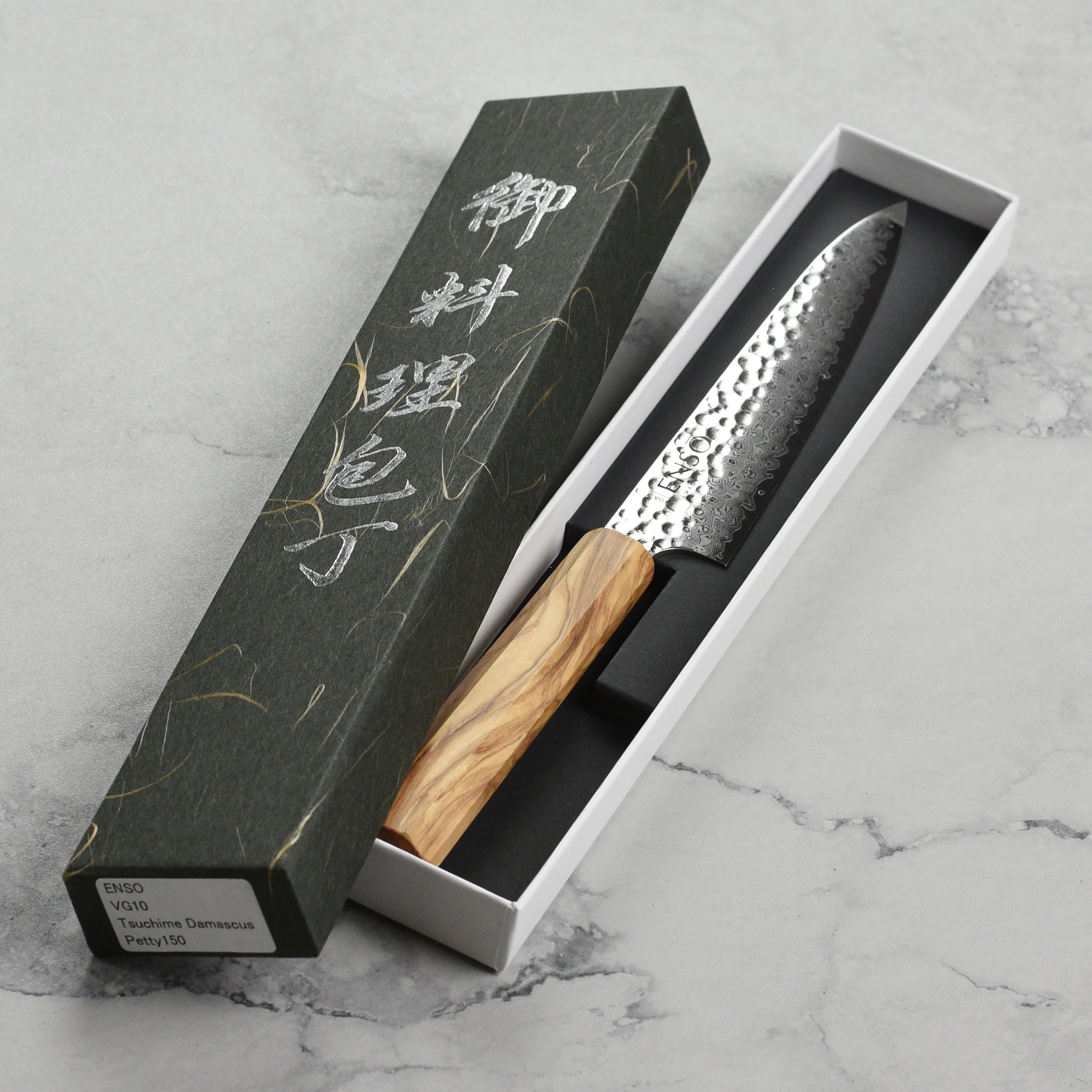 Enso Olivewood petty knife in action, slicing fresh vegetables in a modern kitchen.