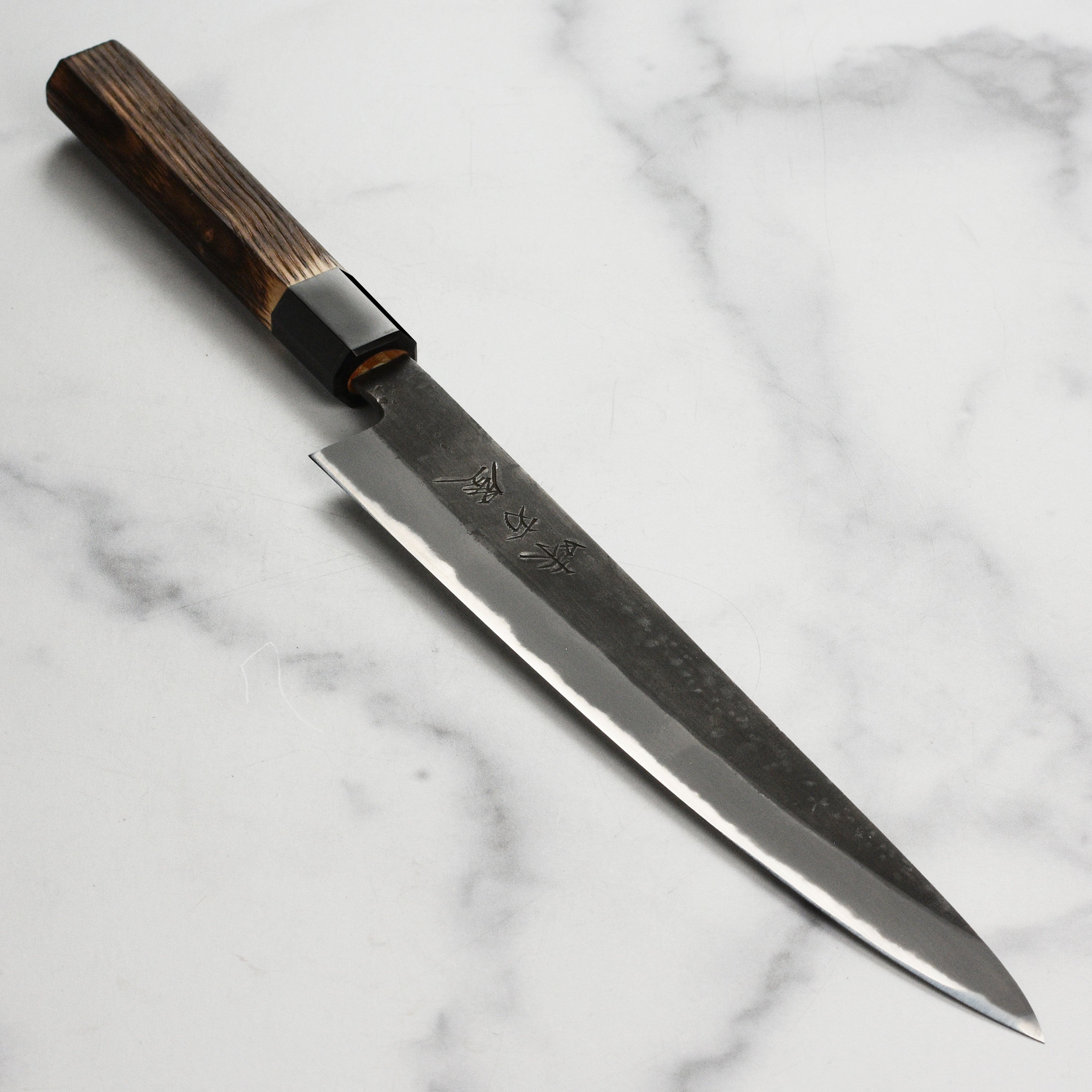 Hinoura Shirogami Sujihiki Knife showcasing sharp blade and elegant design.